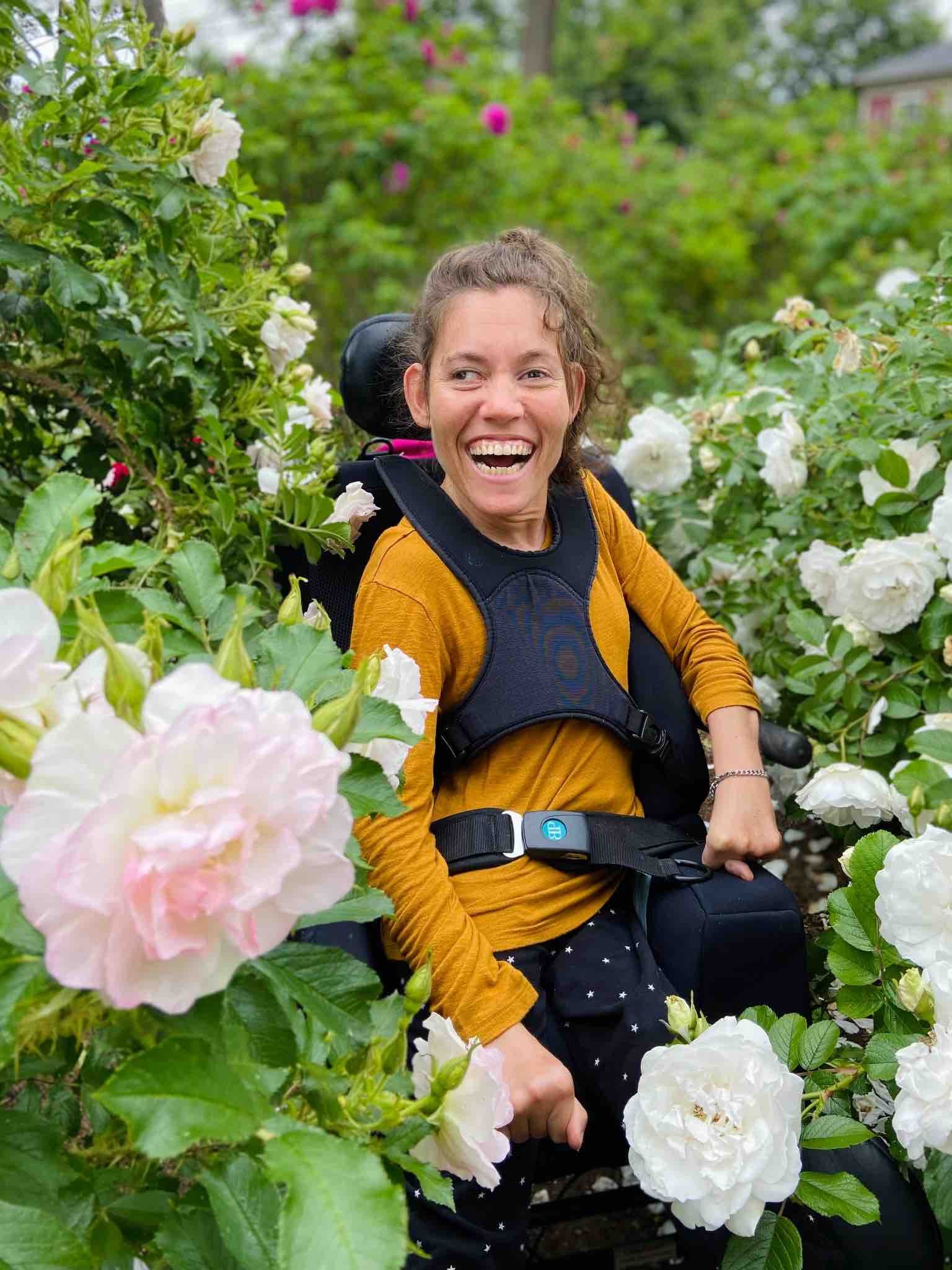 Women smiling and sitting in a garden with beautiful pink flowers. (Copy)