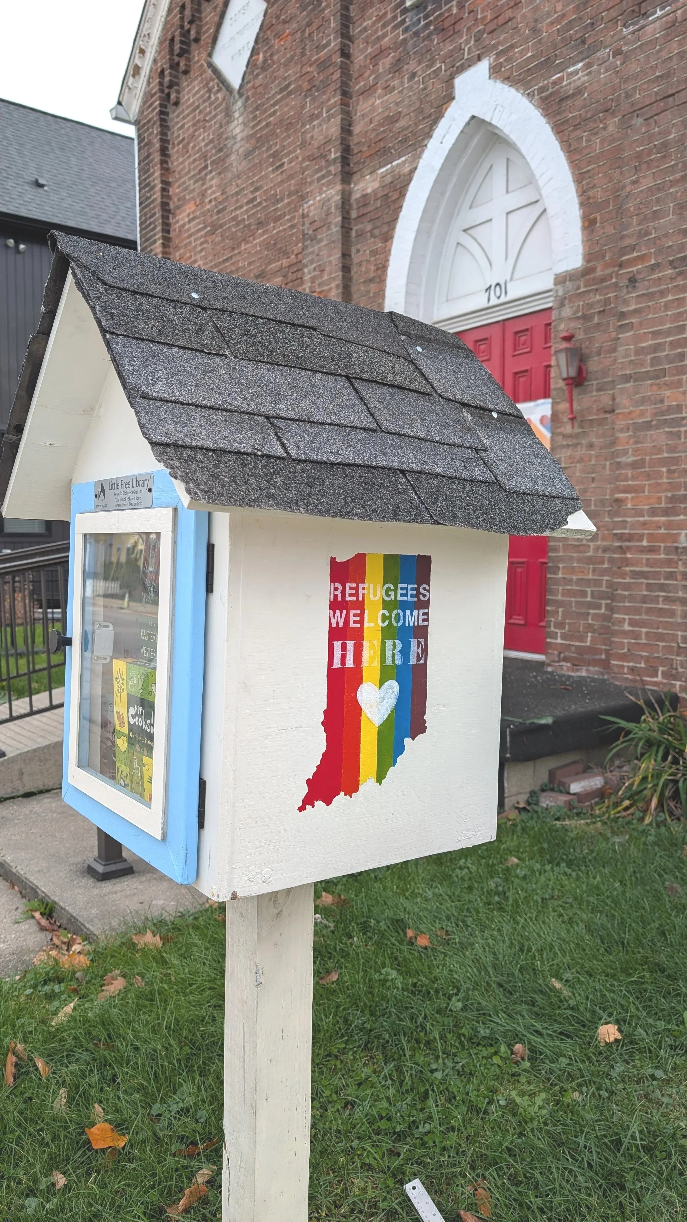 Interior rendering of Lille Bønne with a balcony, featuring a sitting area with a sofa, armchairs, a dining table with chairs, and decorative stained glass window.