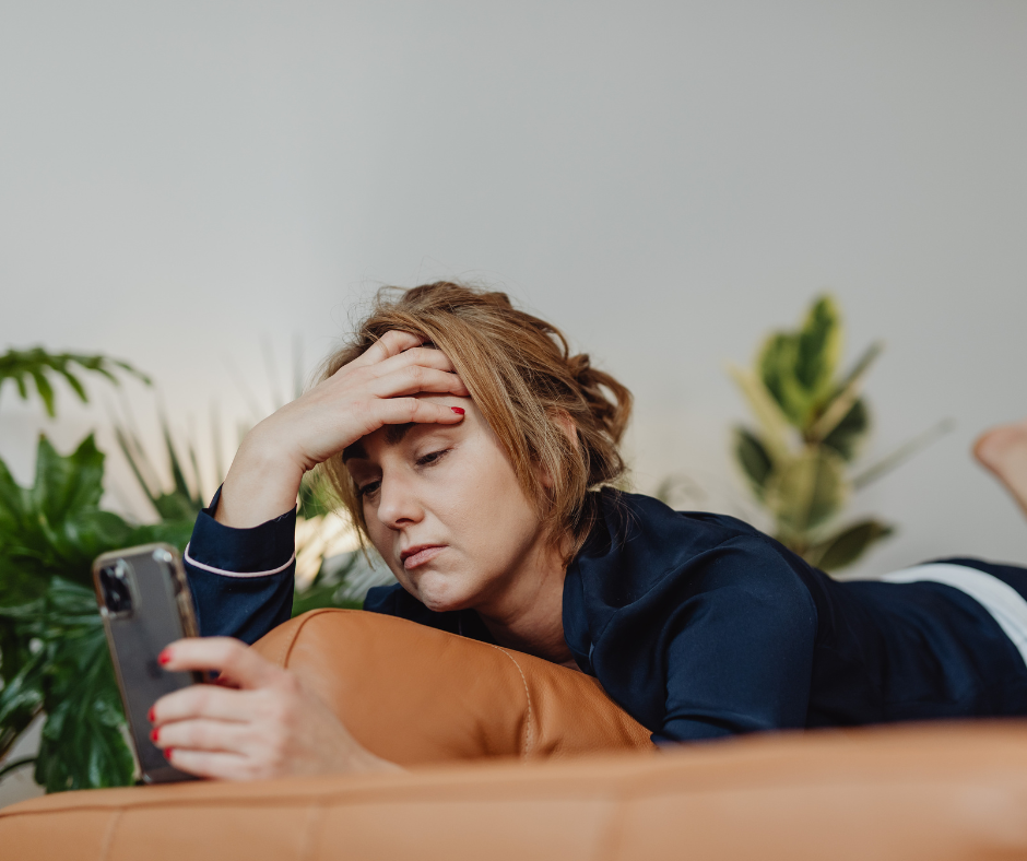 woman bored laying down looking at her phone