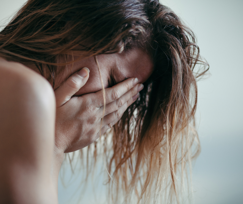 close up of woman with her head in her hands sad weeping