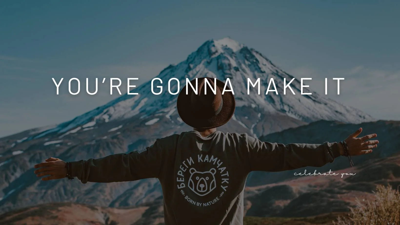 man in front of a mountain view with open arms