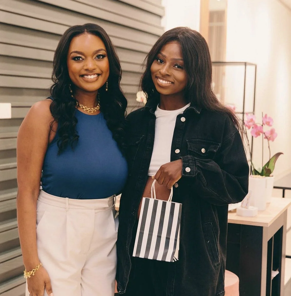 Laurie’s customers, Mariana and Carmen holding hands on a green lawn on their wedding day.