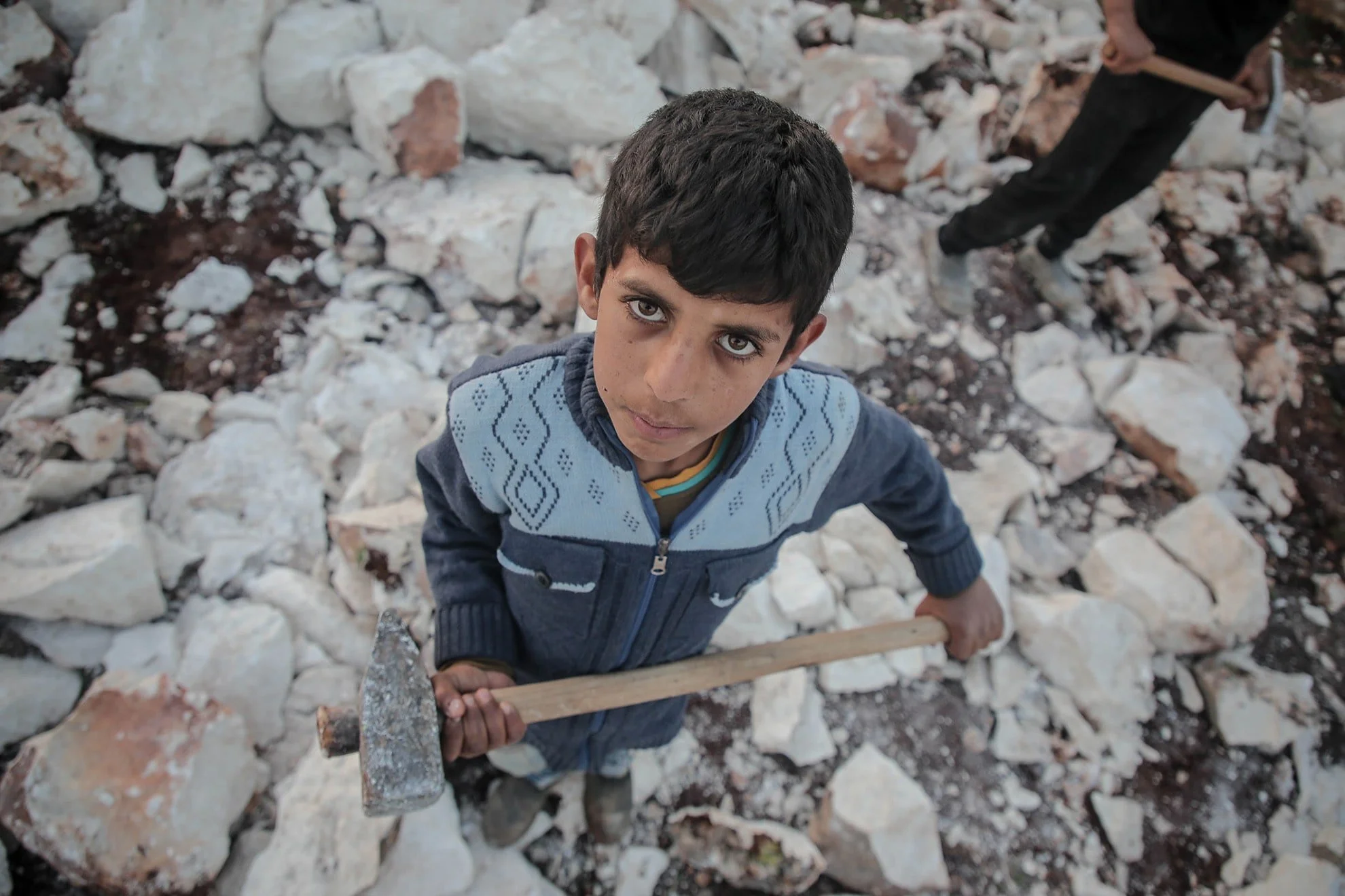 A child miner looking at the camera with a tired face and sad eyes
