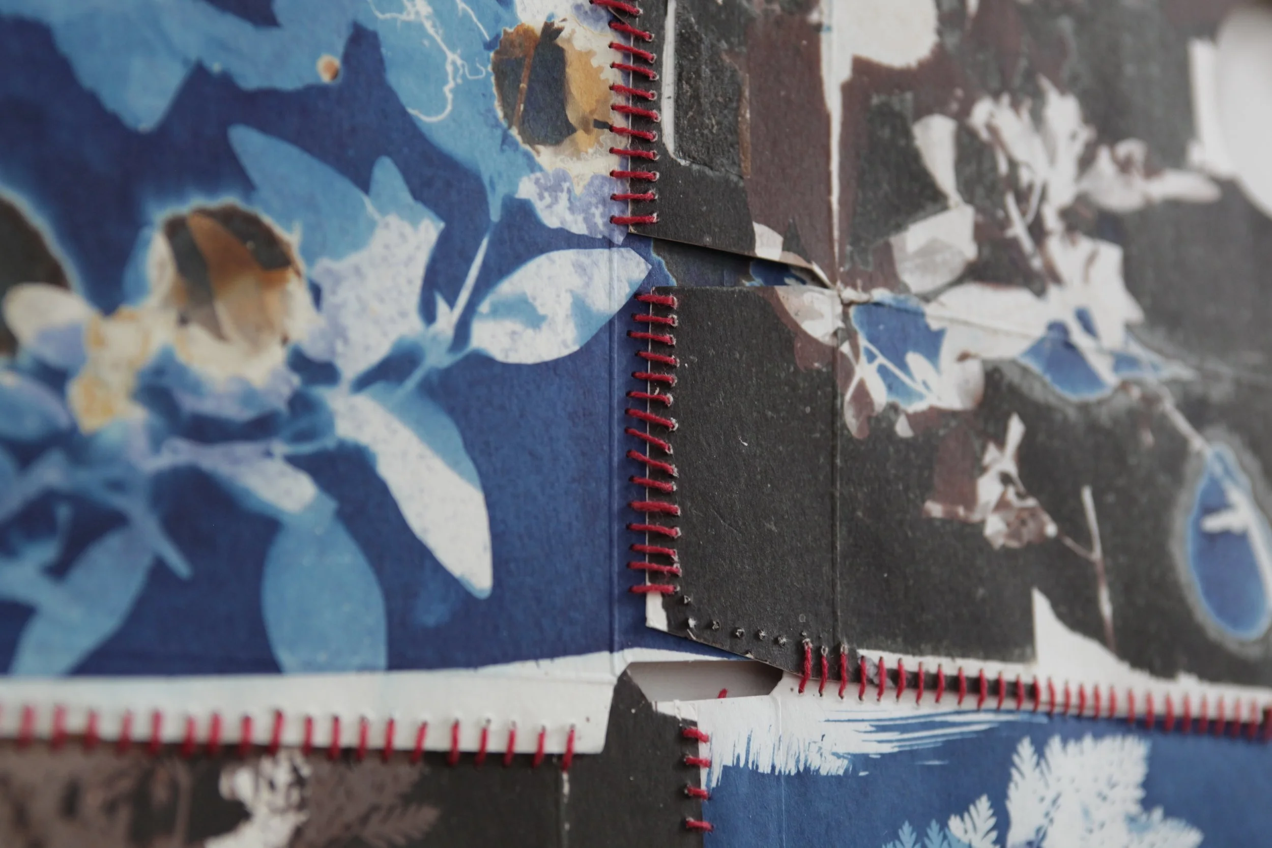 Detail of a 4 piece panel made from recycled boxes stitched together