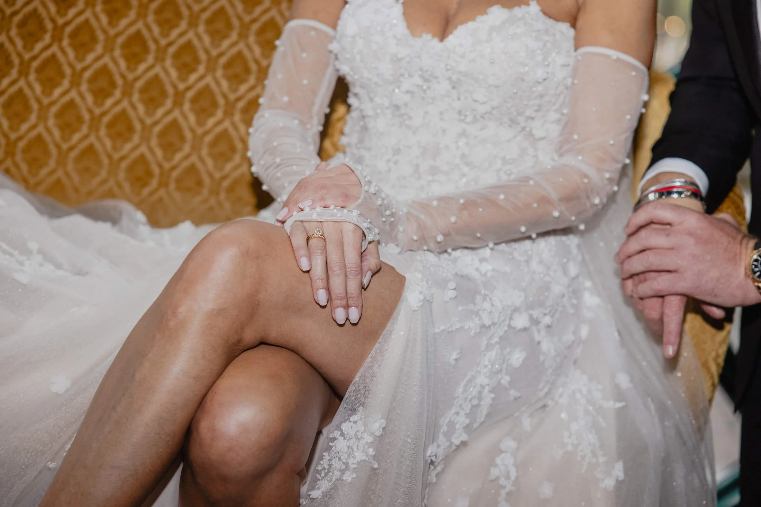 Detail of Vanessa’s textured wedding gown, embellished sleeves and wedding rings at Café Opera