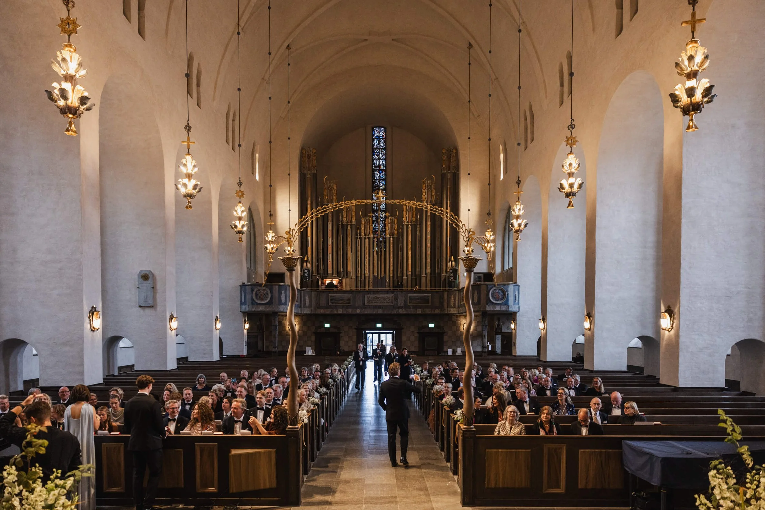Grand interior of Högalidskyrkan filled with guests before the wedding ceremony