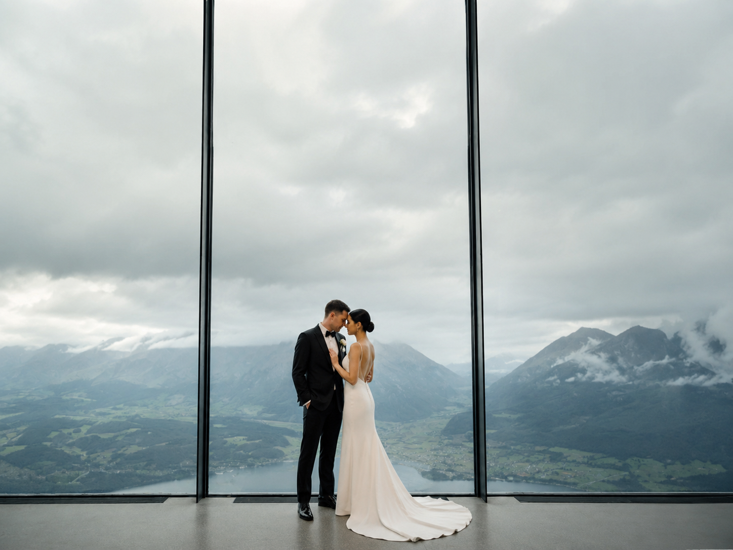 Intimate wedding couple at LUMEN Museum in the Dolomites with panoramic mountain views through floor-to-ceiling windows, cinematic documentary-style destination wedding photography in Northern Italy.