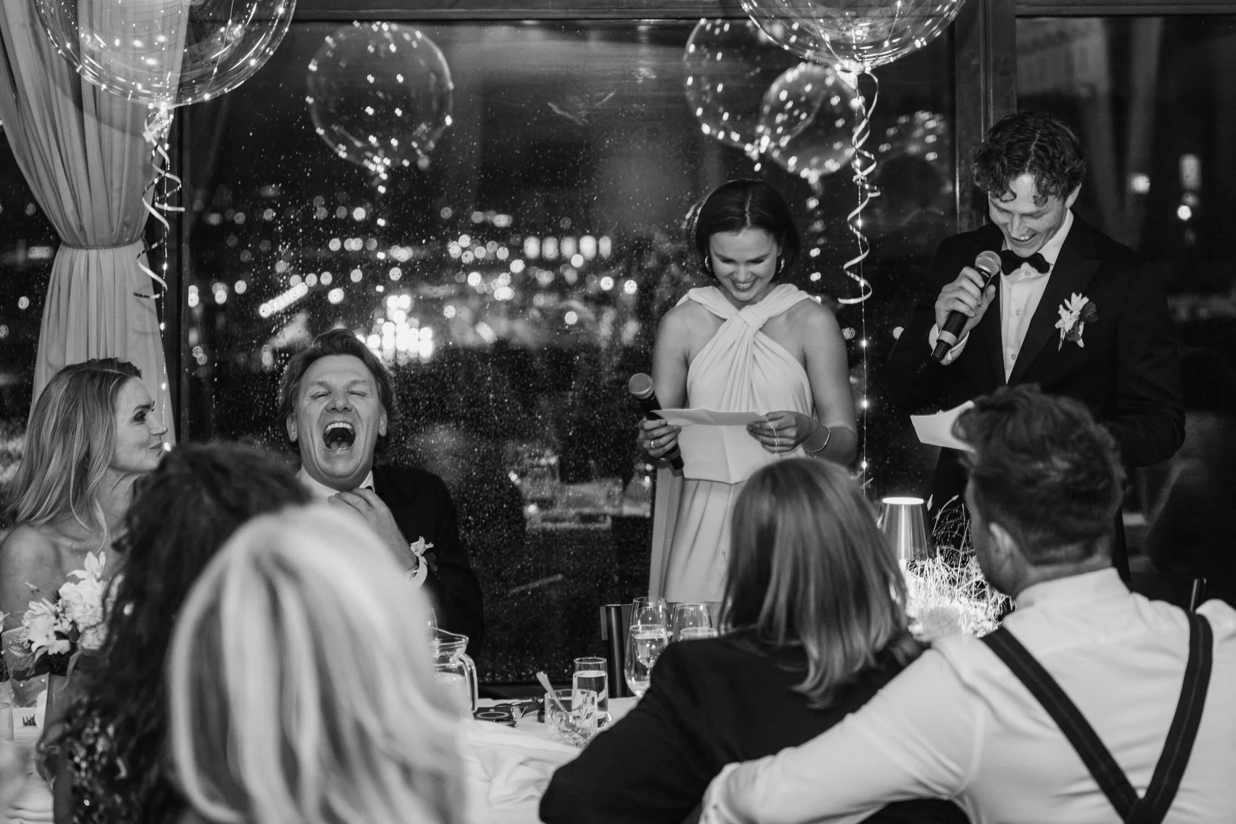 Groom laughing during a heartfelt wedding speech at Café Opera in Stockholm
