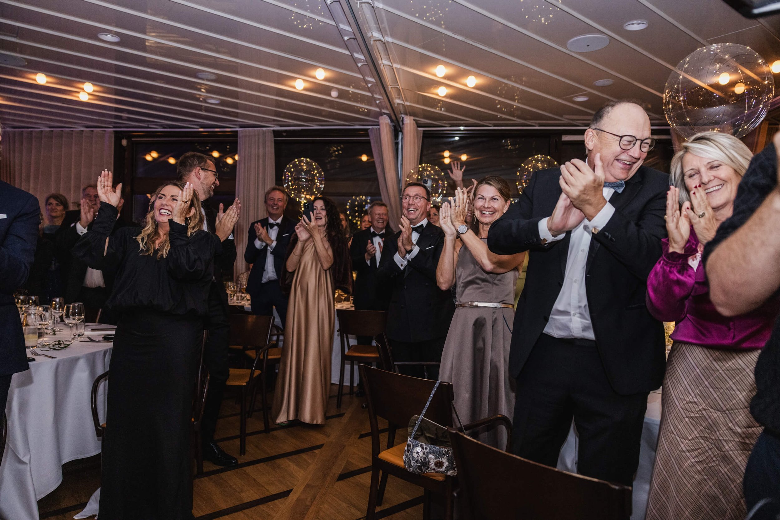 Wedding guests standing and applauding during dinner at a Café Opera reception