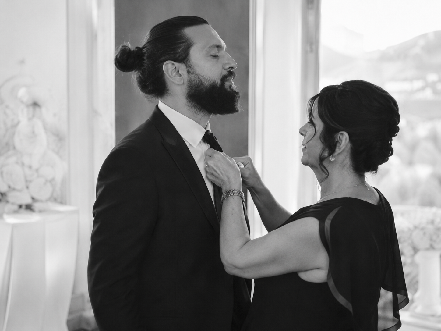 Black and white getting ready moment at Grand Hotel Tremezzo with groom adjusting his tie before the Lake Como wedding ceremony.
