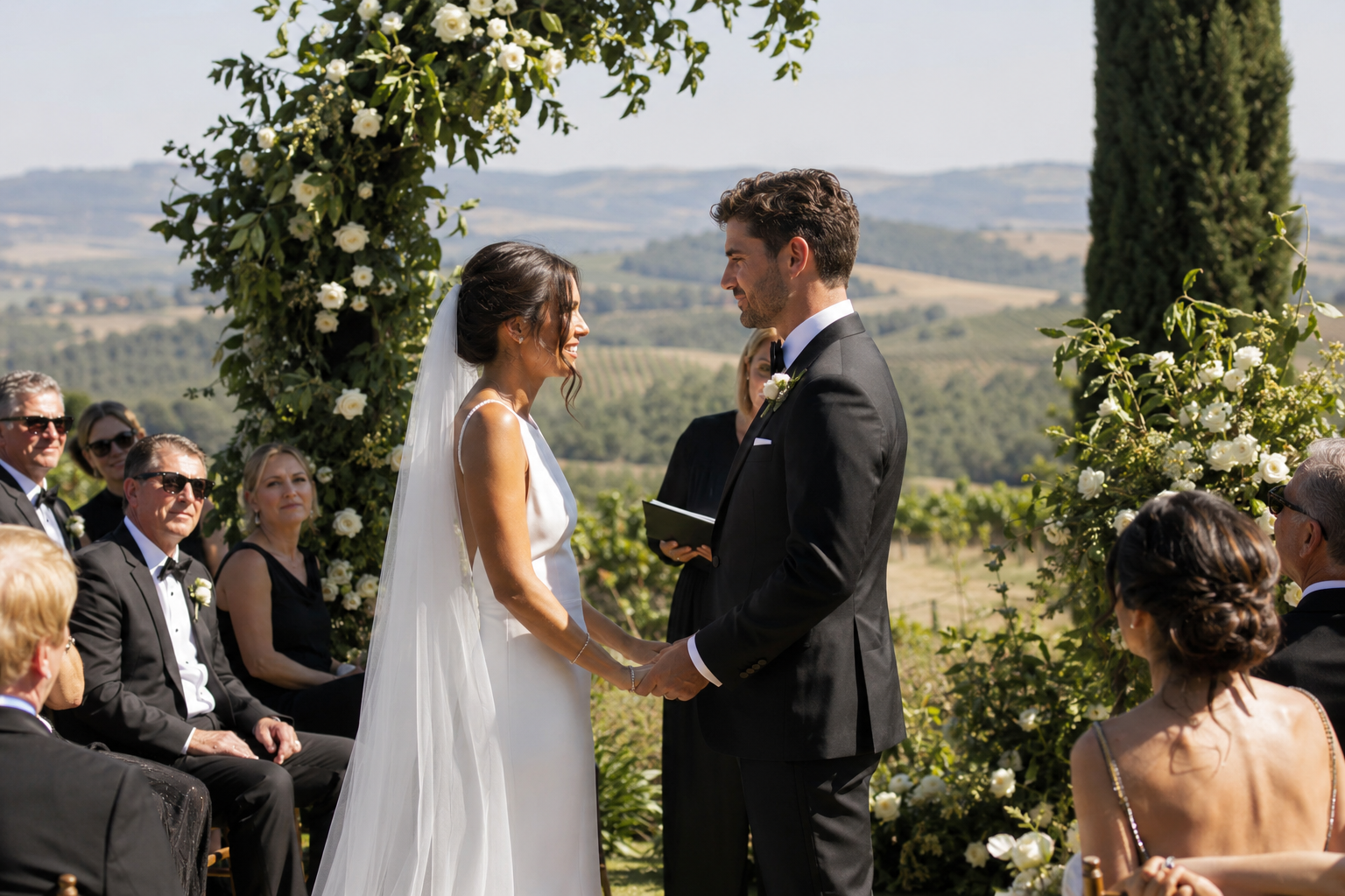 Outdoor Tuscany wedding ceremony overlooking the Tuscan countryside, bride and groom exchanging vows under floral arch at luxury Italian villa venue, destination wedding photography in Tuscany by WeddingStudio.se