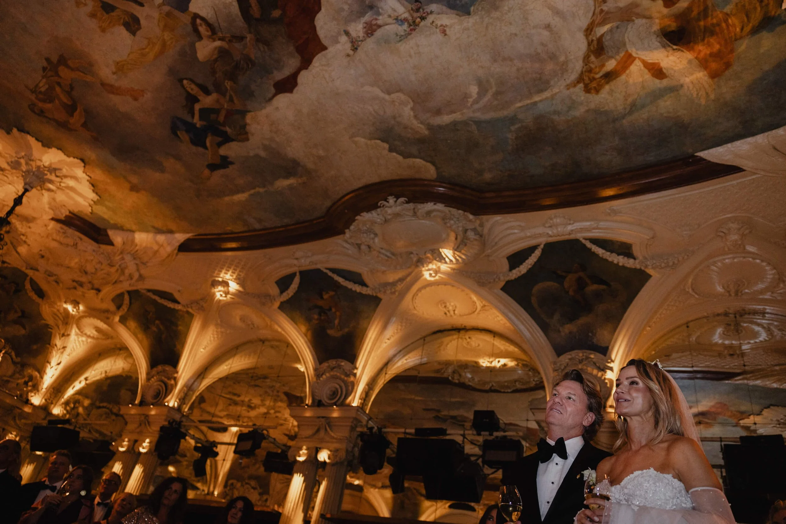 Elegant wedding reception beneath the historic ceiling and chandeliers of Café Opera Stockholm