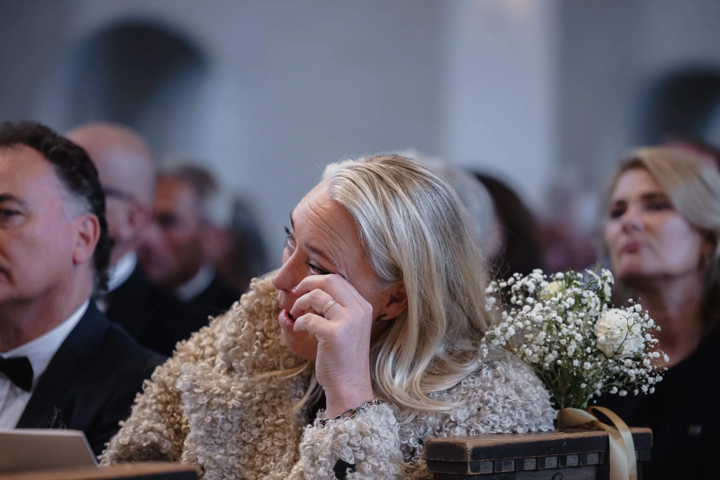 Wedding guest wiping away a tear during the Högalidskyrkan ceremony