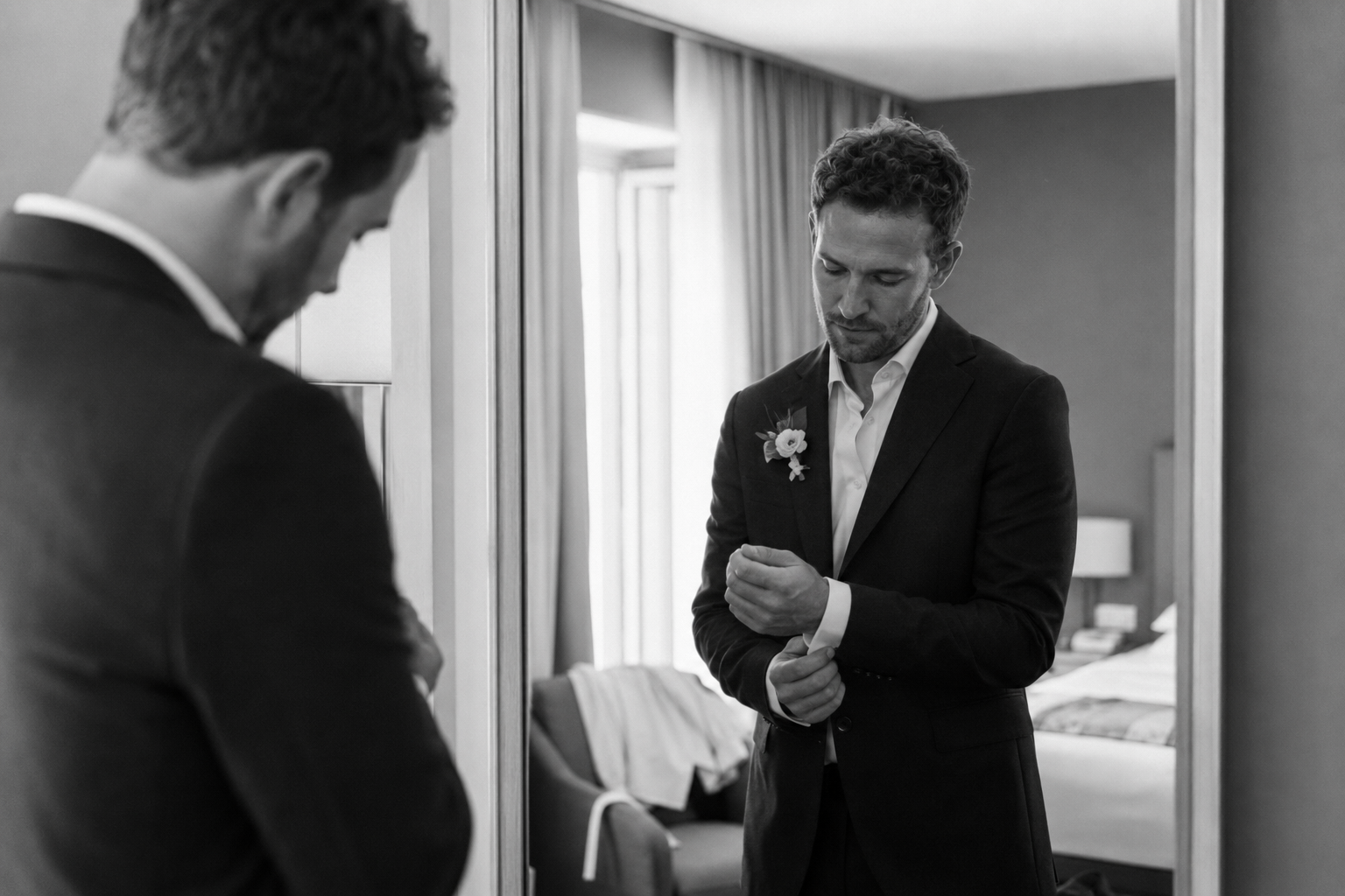Groom adjusting his cufflinks while getting ready in Riva del Garda before his destination wedding on Lake Garda.