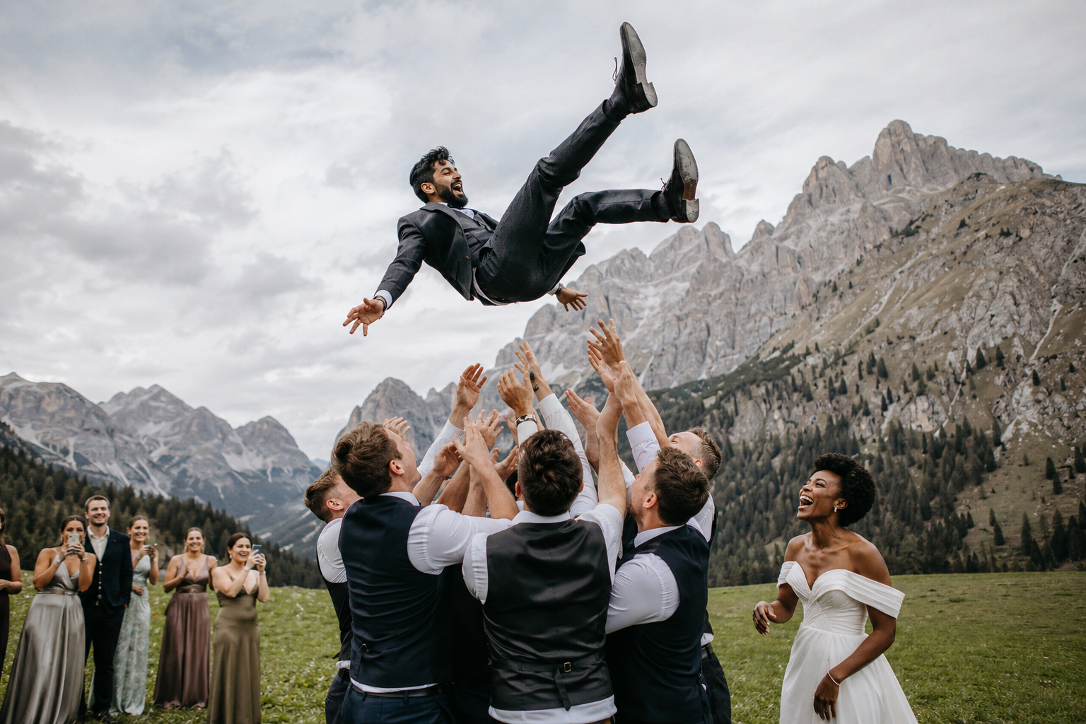 Guests tossing the groom into the air during an outdoor Dolomites wedding, with dramatic alpine peaks creating an unforgettable mountain backdrop.