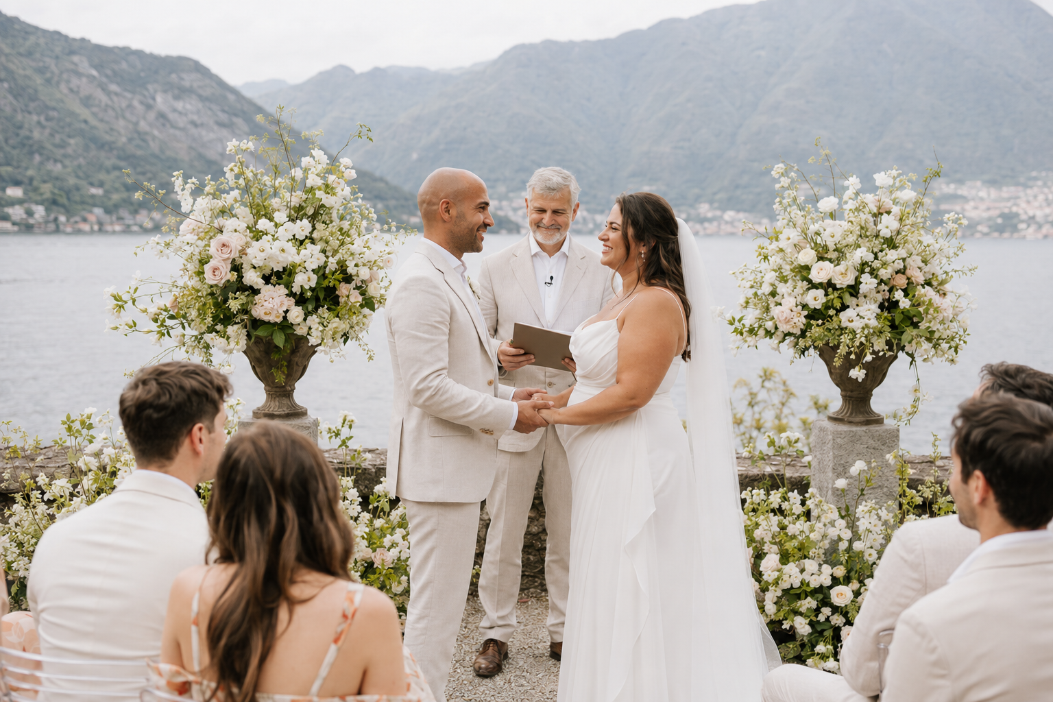 Lake Como wedding ceremony with mountain views and white floral arrangements, captured in a natural documentary style.
