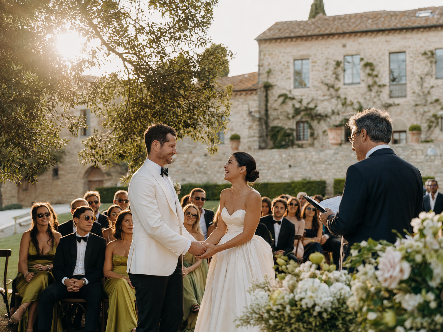 Outdoor wedding ceremony at Borgo Stomennano in Tuscany with the bride and groom exchanging vows surrounded by guests.