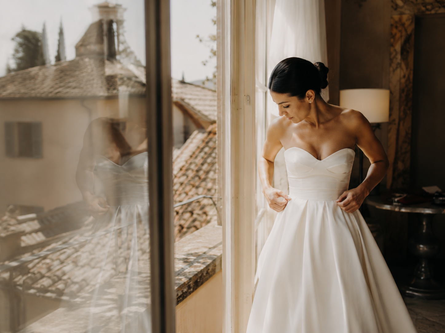 Bride getting ready inside Borgo Stomennano with soft natural light and views over the Tuscan countryside before the wedding ceremony.