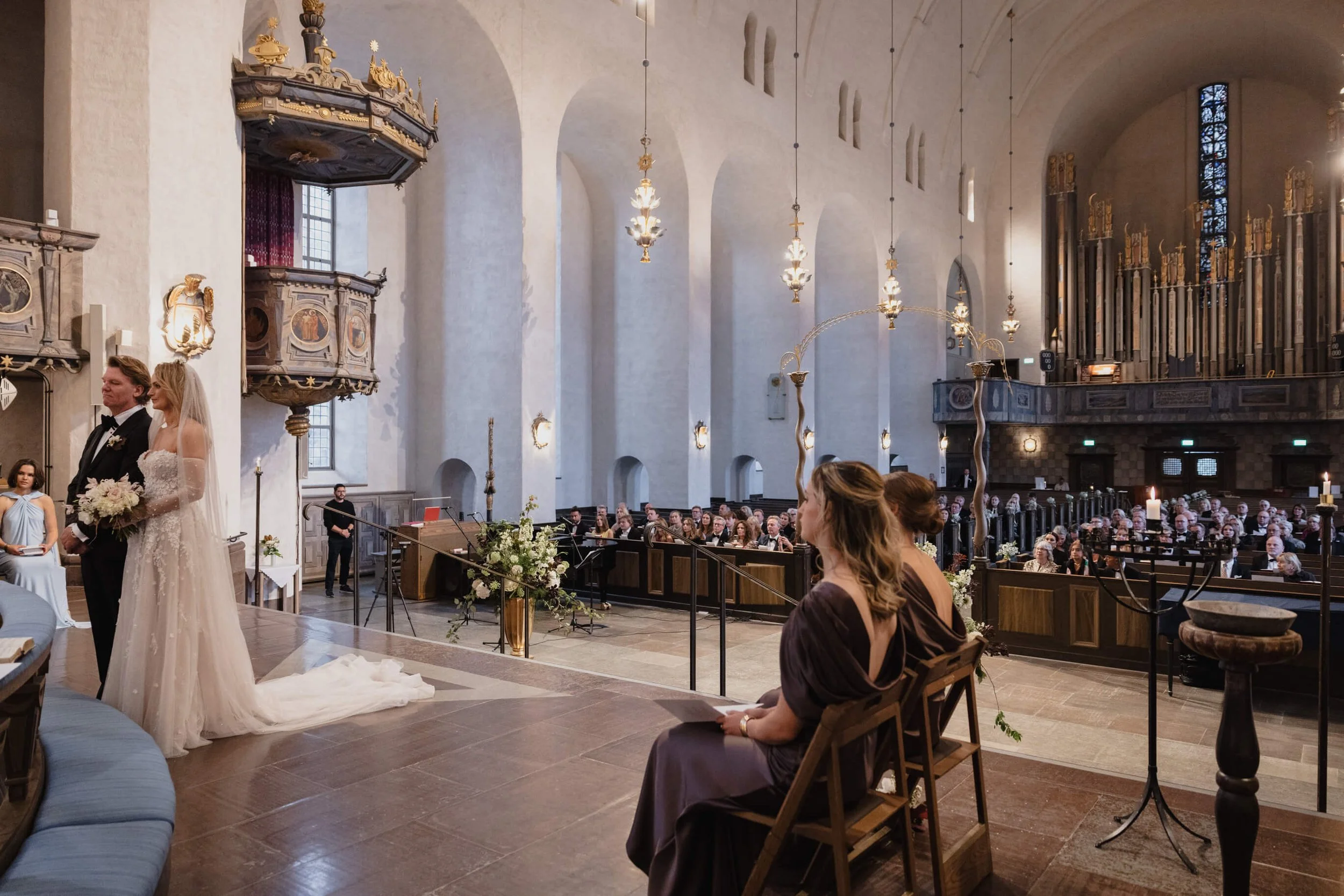Vanessa and Jens at the altar during their international wedding ceremony at Högalidskyrkan
