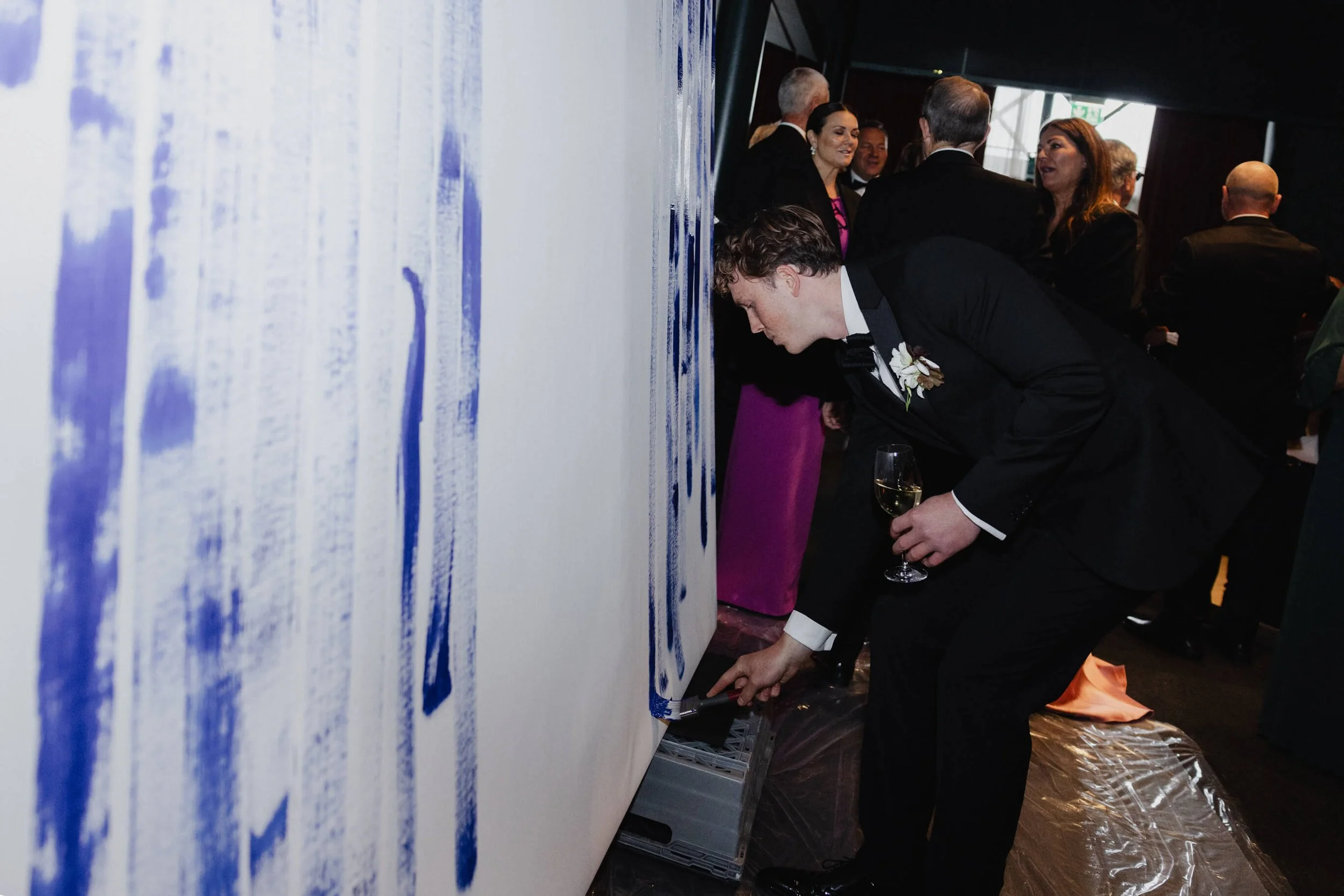 Wedding guest adding a blue brushstroke to Jeppe Hein’s collaborative artwork at Café Opera