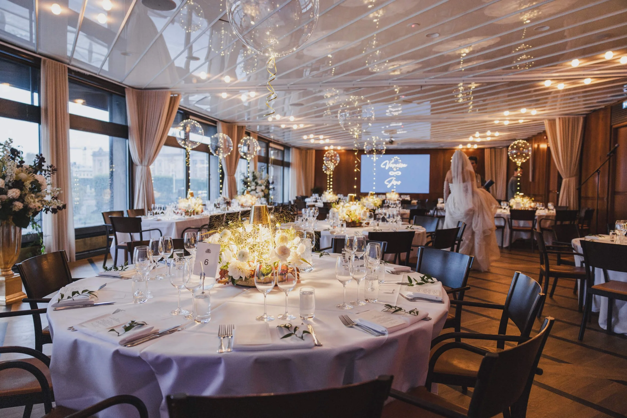 Wedding dinner tables, floral arrangements and illuminated balloons prepared at Café Opera Stockholm