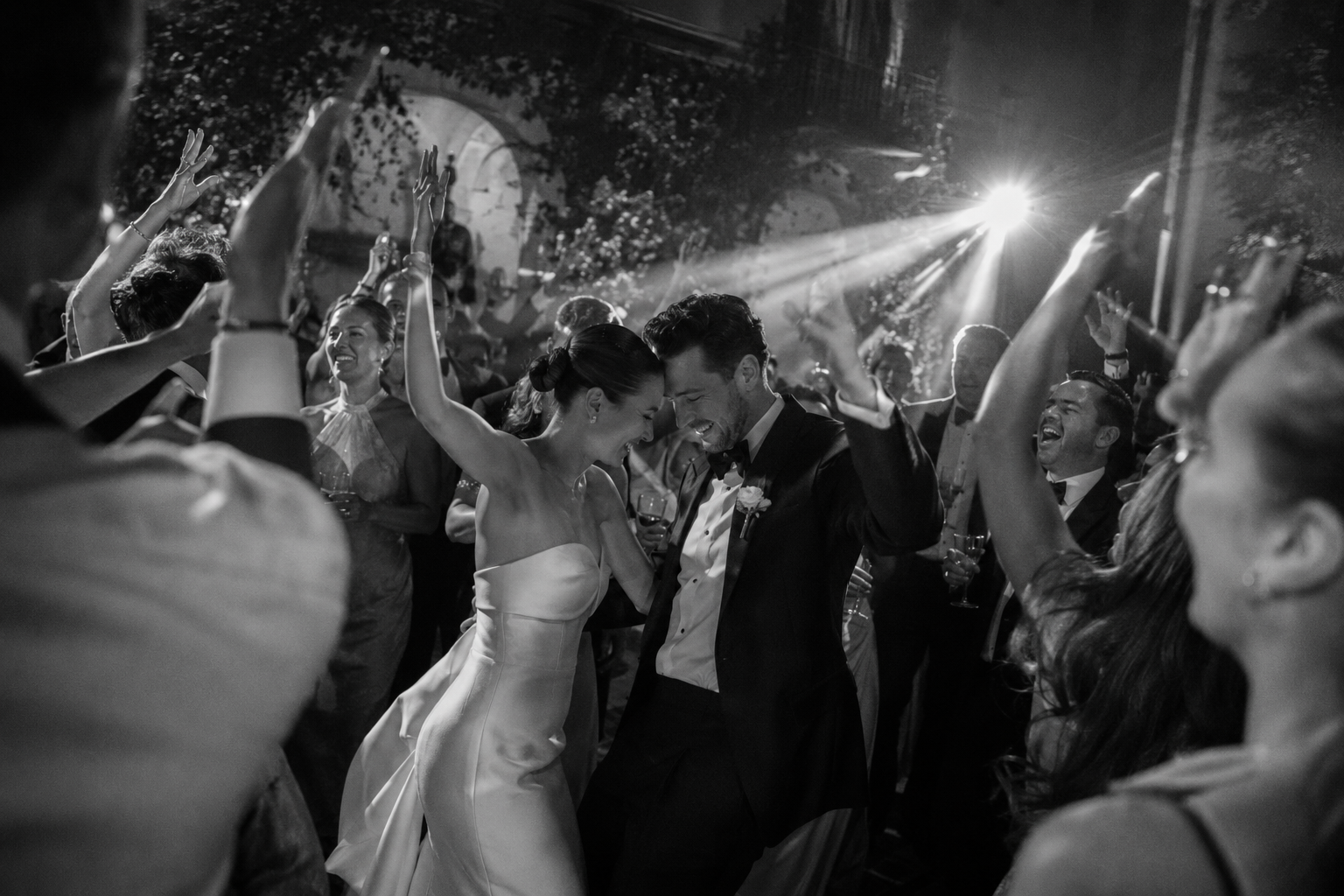Bride and groom dancing with guests during a joyful Lake Garda wedding party at a luxury Italian villa.