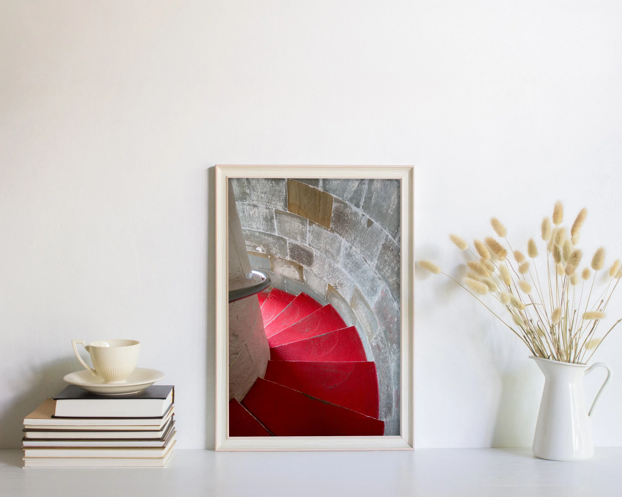 Ruokapöydän yllä on kolme mustavalkoista taulua, joissa on erilaisia kuvia Lågskärin majakalta: portaikko, majakka ja lyhty. 