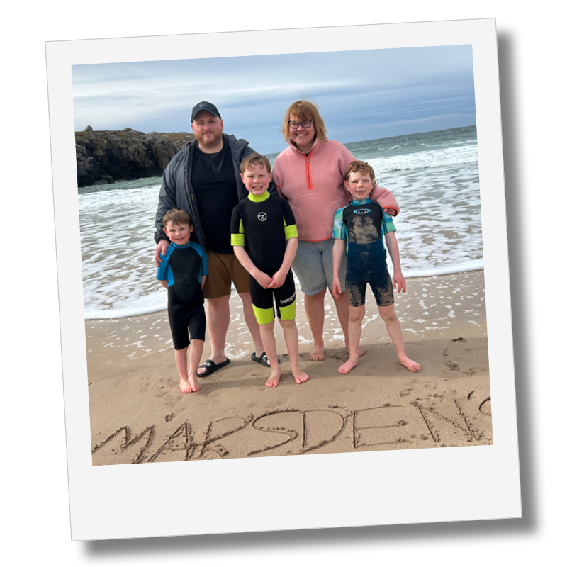 Marsden Makes Co. A family of five on the beach, standing behind the word 'MARSDEN' written in the sand. Core Value for Marsden Makes Co - Family