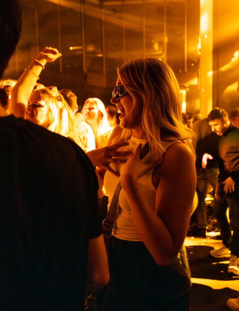 Frauen feiern auf einer Party im Club, lachen und haben Spaß, im warmen Licht.