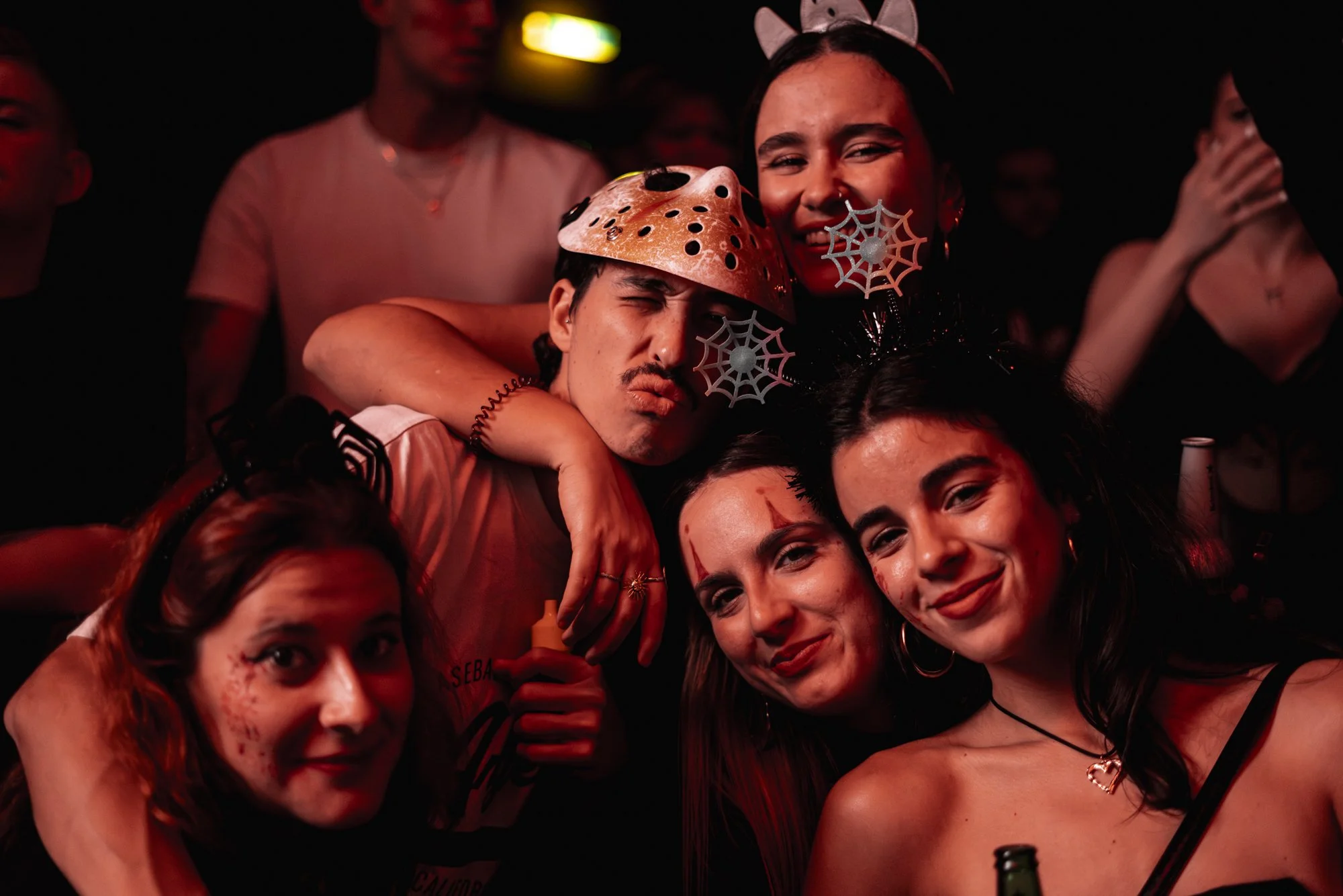 Gruppe von jungen Menschen in Halloween-Kostümen bei einer Party, die lachen und Spaß haben.
