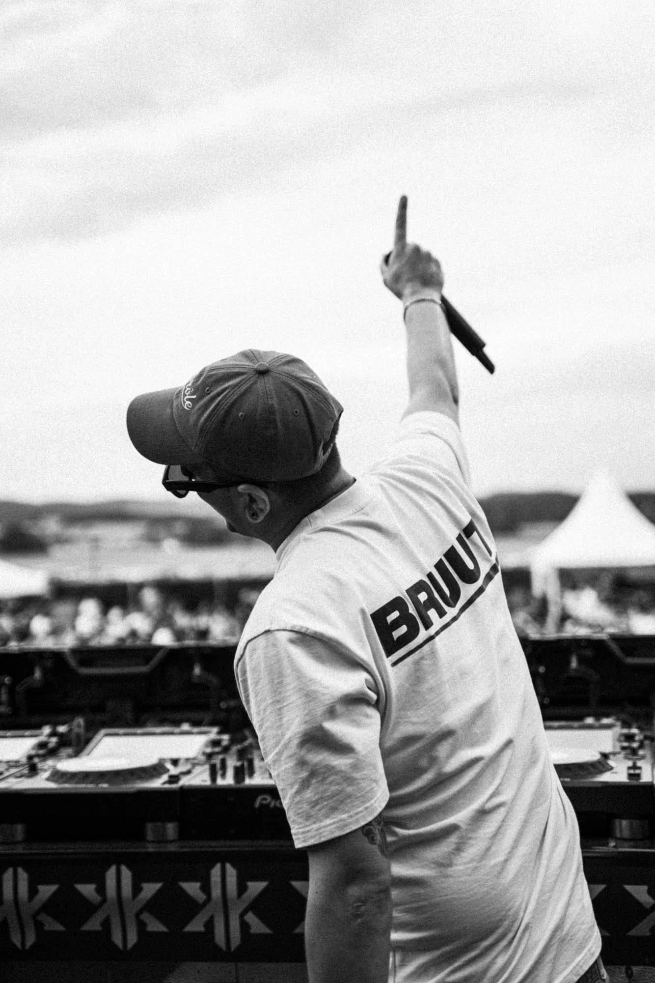 Ein DJ beim Auflegen auf einer Musikbühne während eines Festivals im Freien.