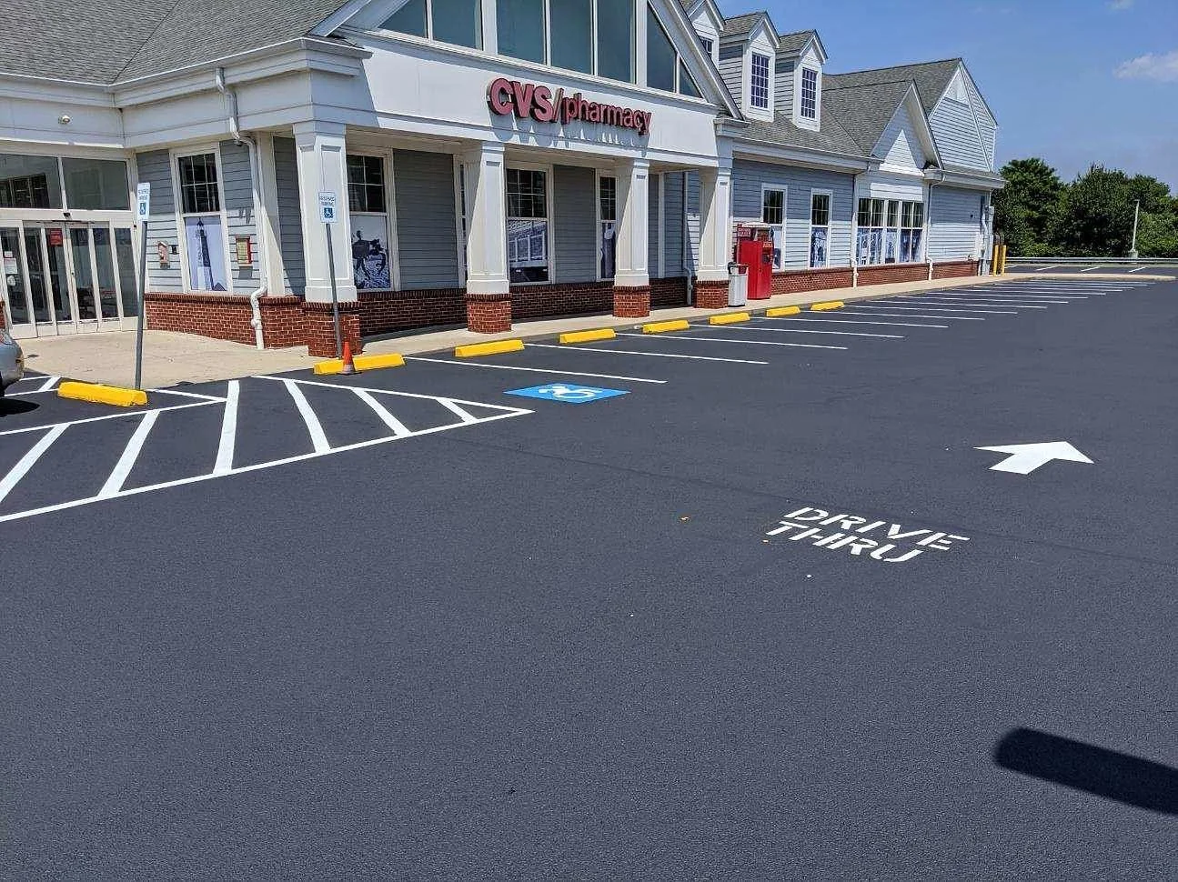 Empty CVS pharmacy parking lot with designated handicap parking space and a marked drive-thru lane.