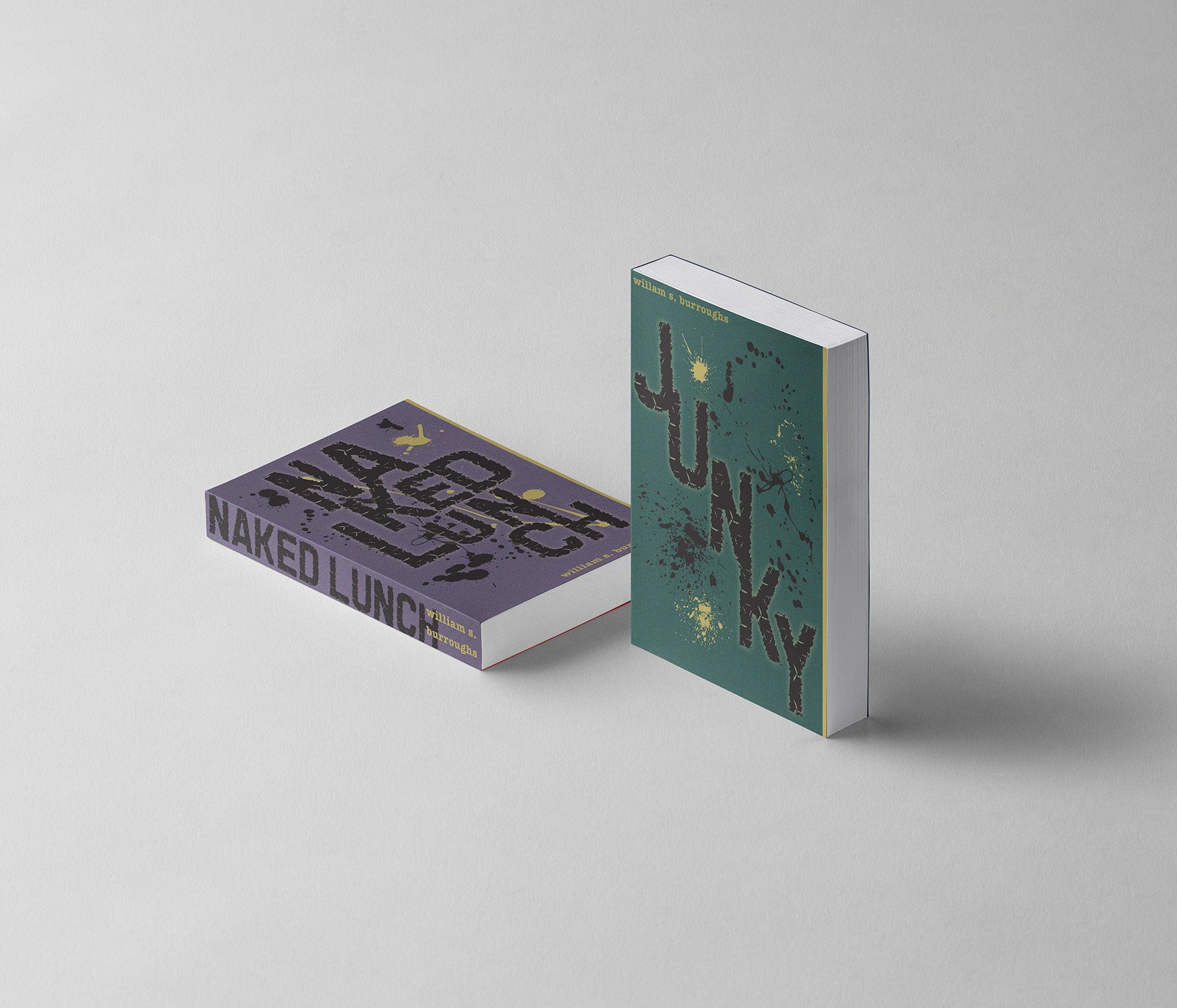 Two books stand upright and one book lies flat on a light gray surface. The book standing upright on the right has a dark green cover with black painted letters and the author's name, William S. Burroughs, in small yellow letters at the top. The flat book on the left has a purple cover with black painted letters that spell 'NAKED LUNCH,' and the author's name on the side.