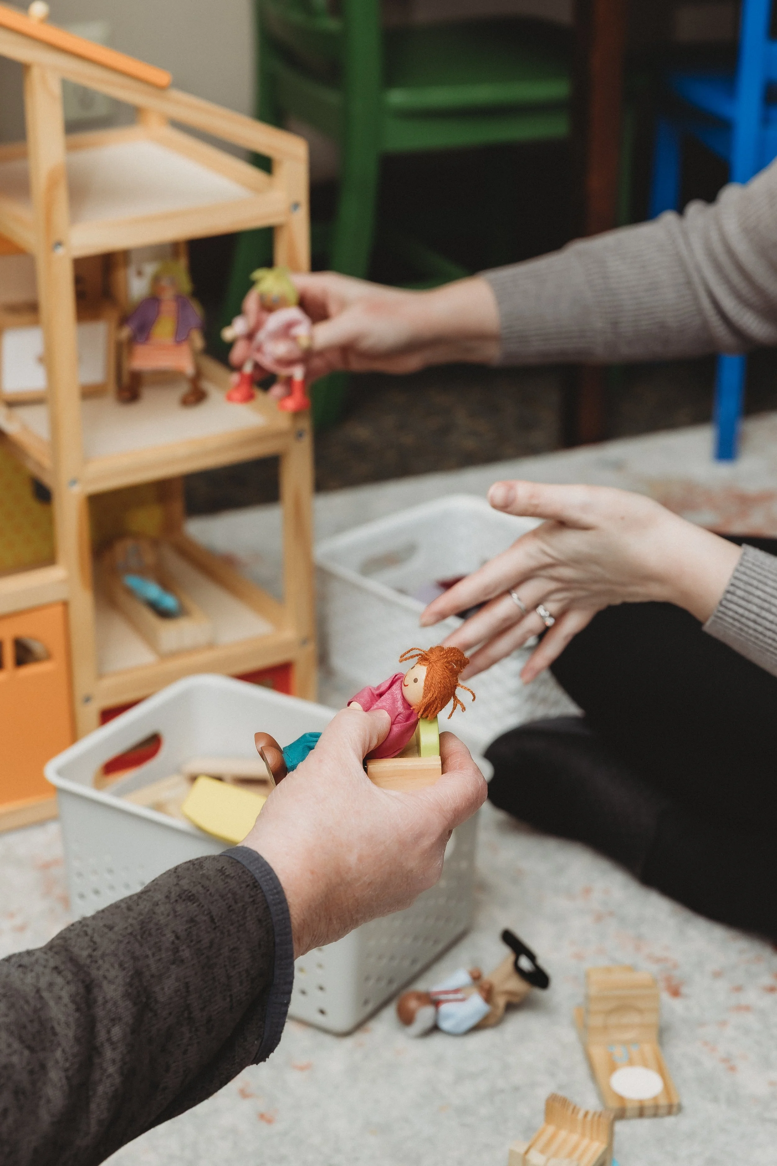 play therapist using dollhouse and dolls with client