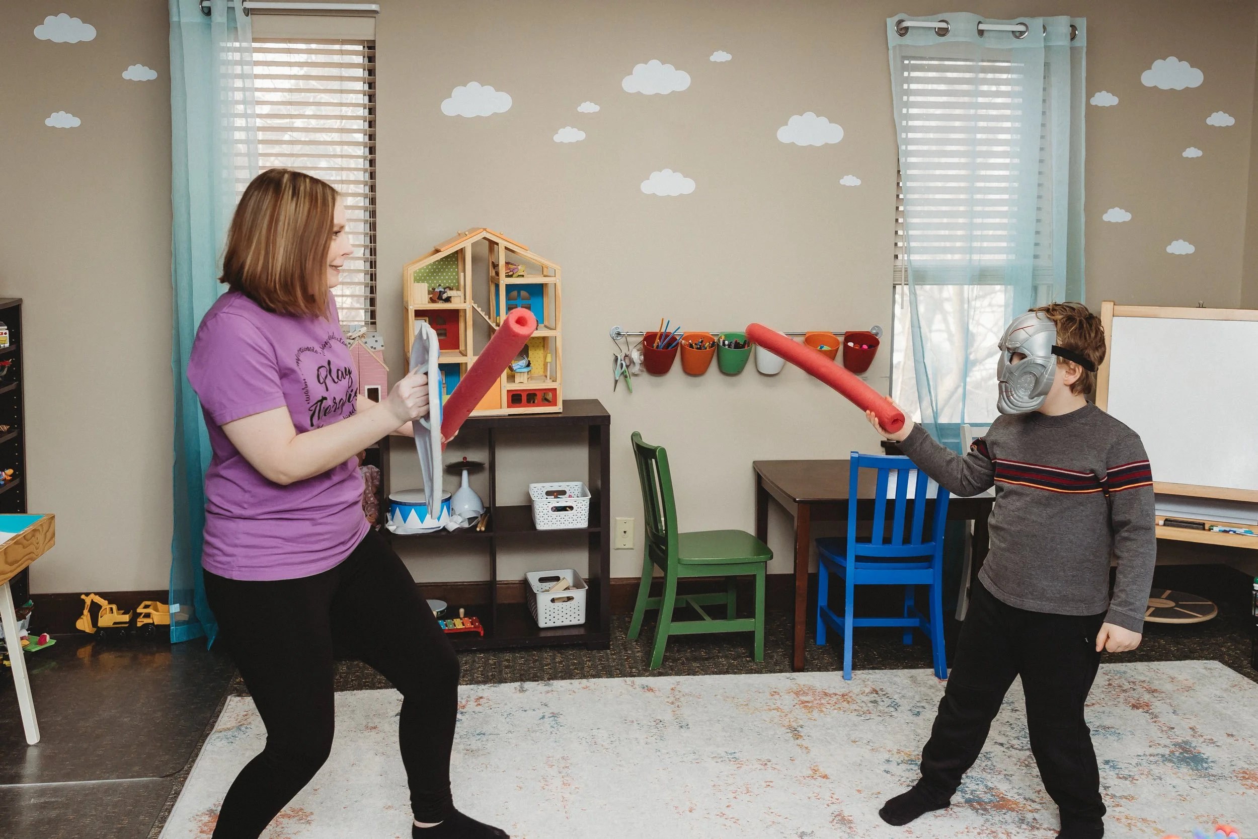 boy laying on bed with headphones and tablet therapy for PDA