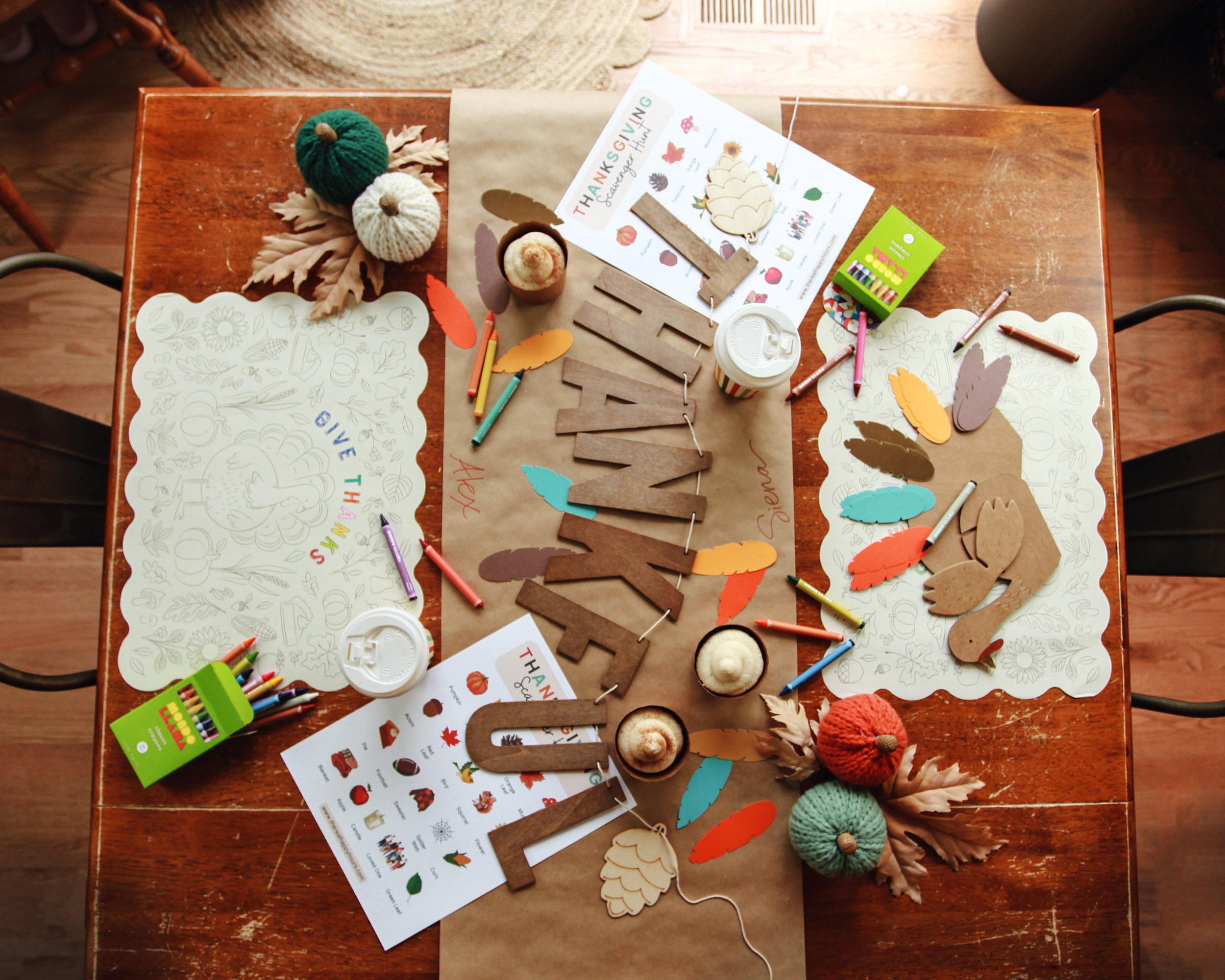 colorful and cute all-in-one Activities + Decor party Box for kids, including decorative pumpkins, a “Thankful” banner, coloring placemats, crayons, a DIY turkey craft, and scavenger hunt