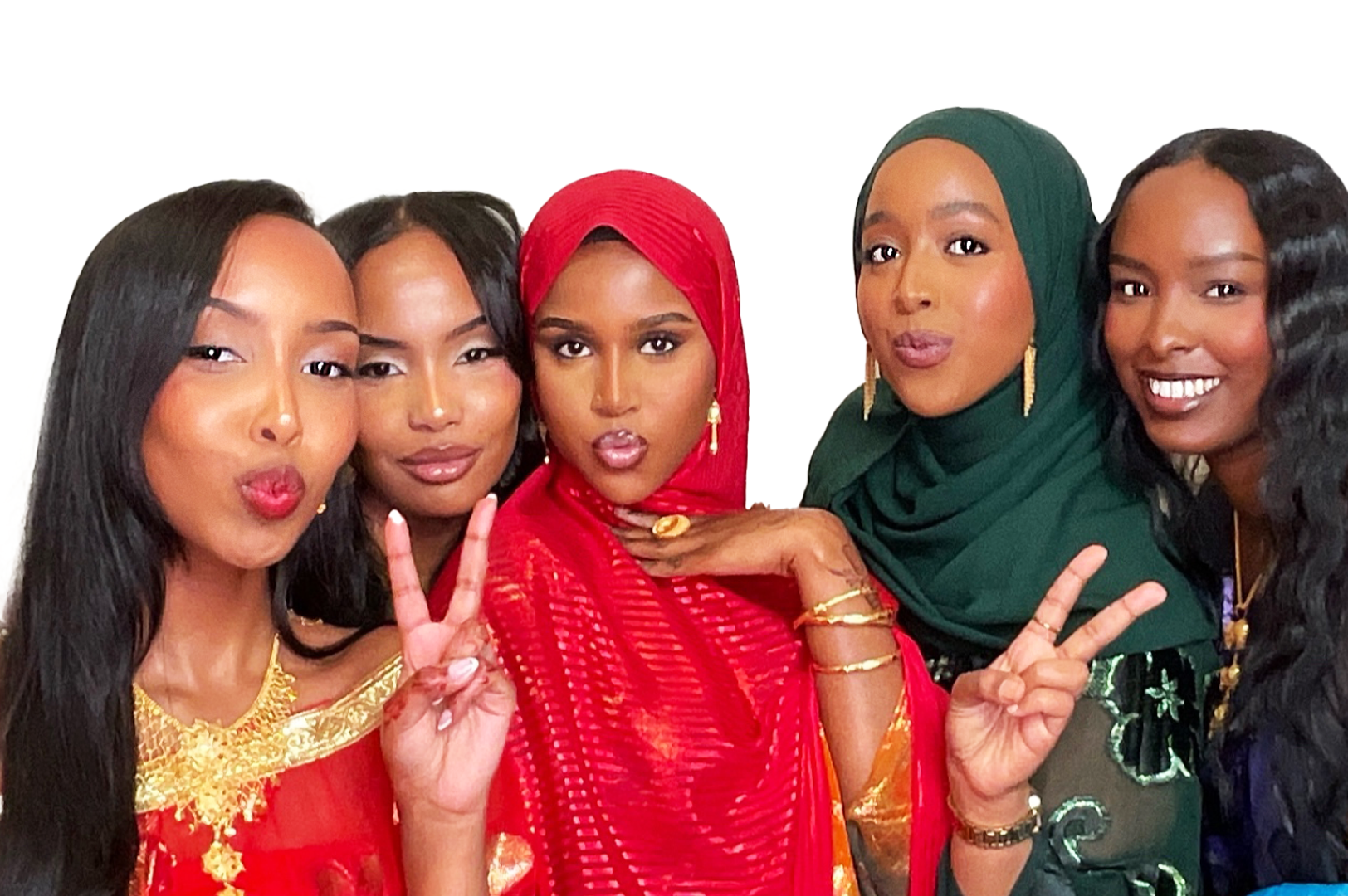 Group of five women dressed in colorful traditional African clothing, smiling and making peace signs with their hands.