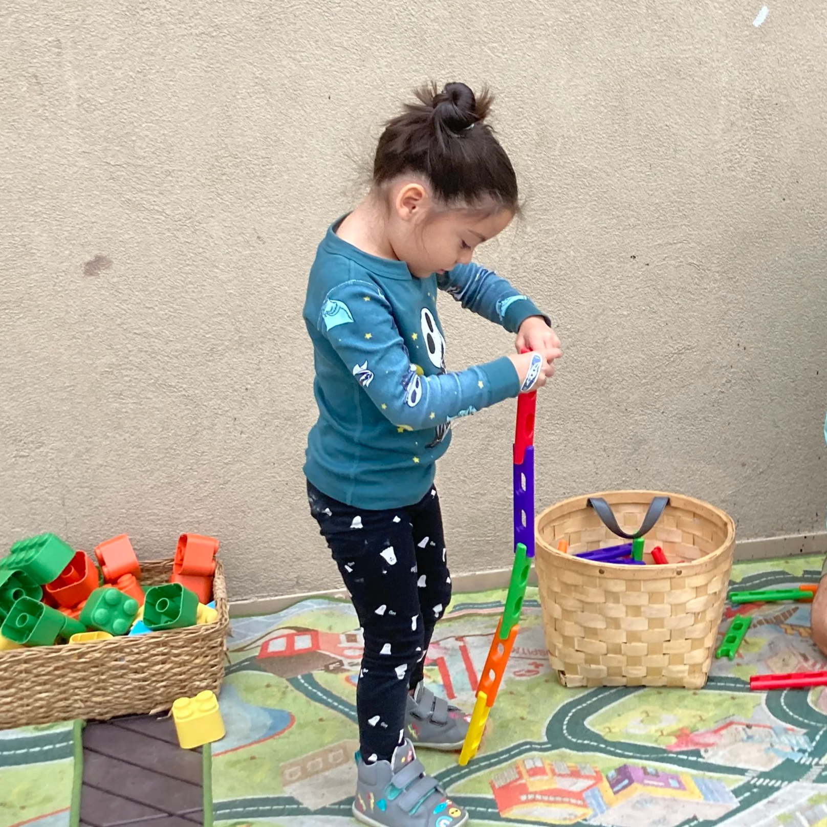 Child building toys with teacher. 
