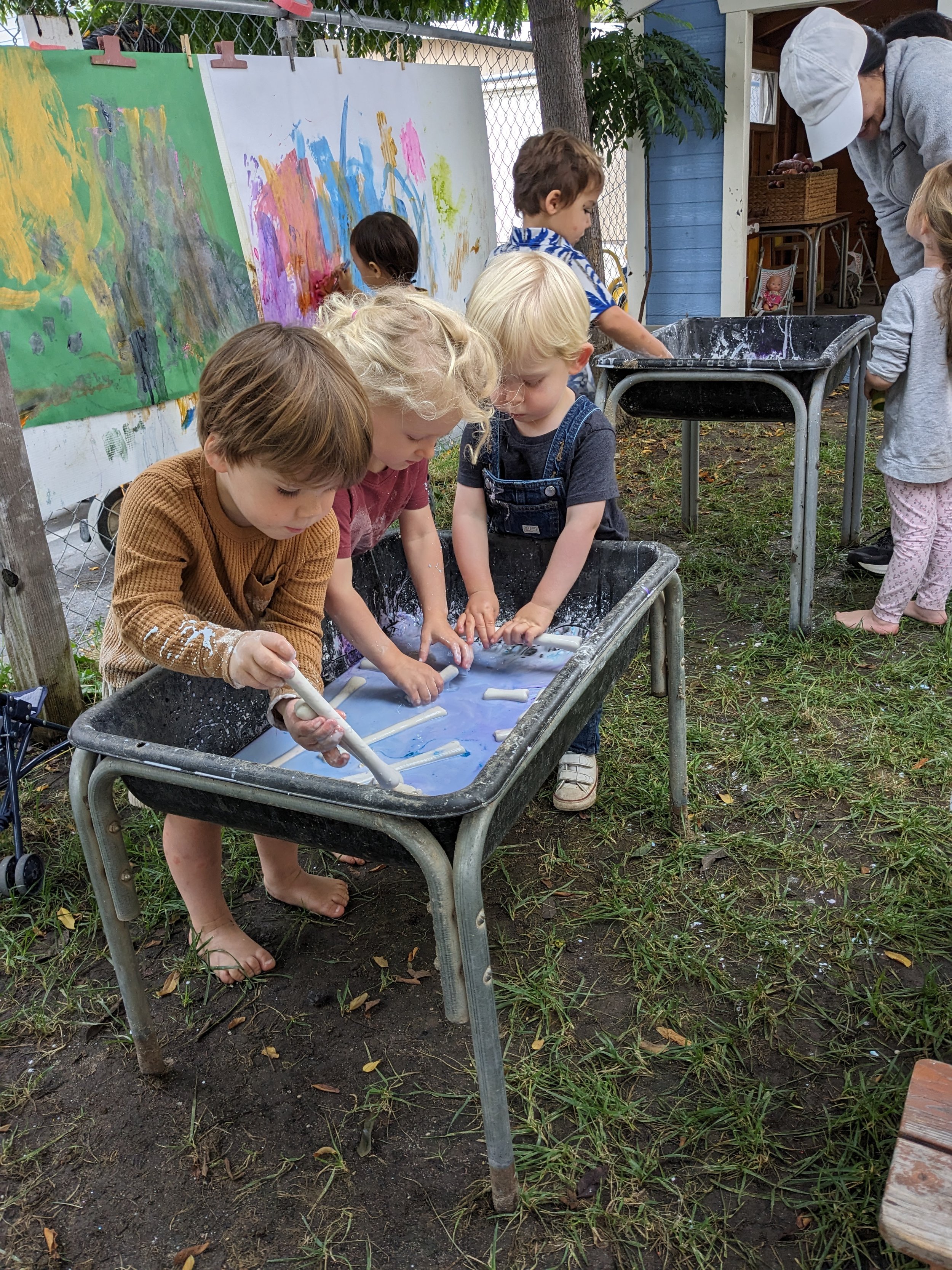 Group of children at activity table, rolling clay.