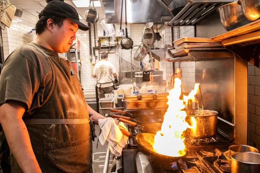 chef ray holding a pan with fire