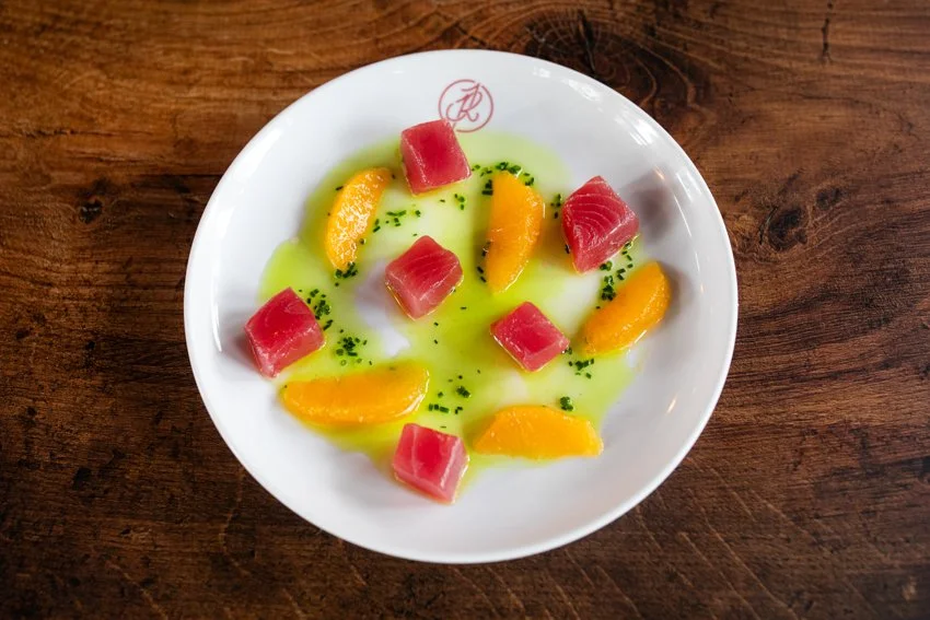 crudo on a white plate with a wooden background