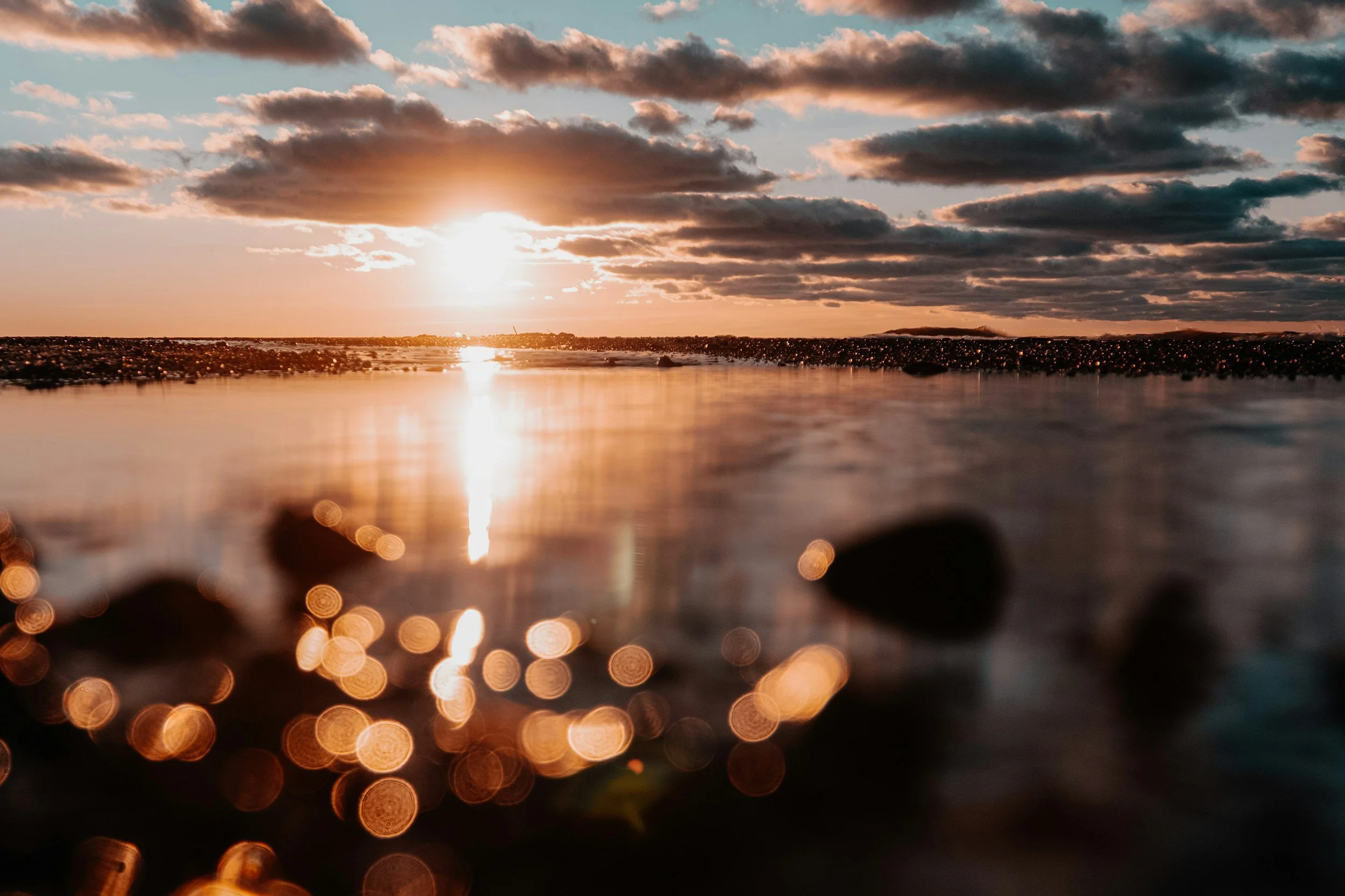 A calm Ohio sunset over water with clouds in the sky and reflections on the surface.