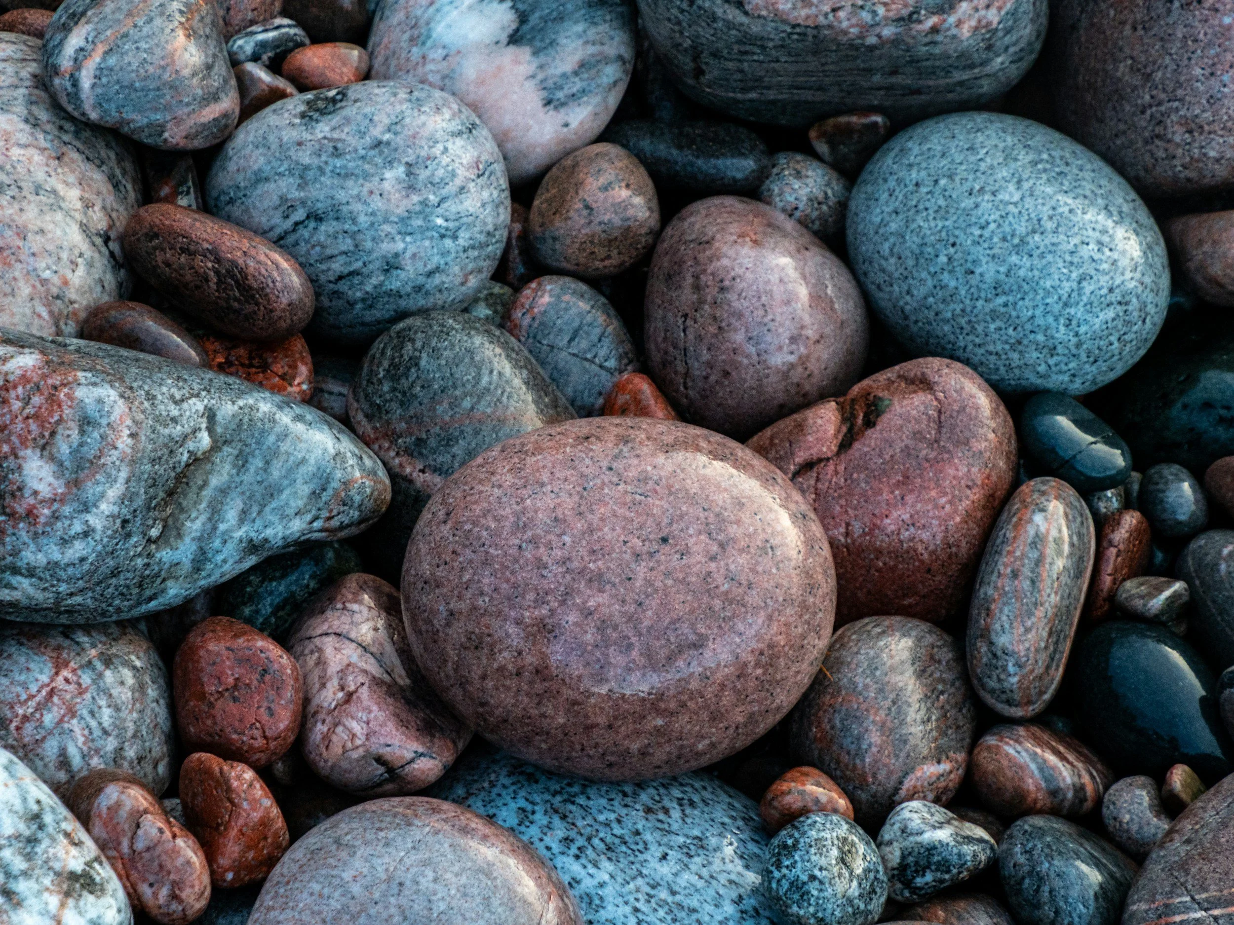 A collection of grounding, smooth, rounded rocks of various sizes and colors.