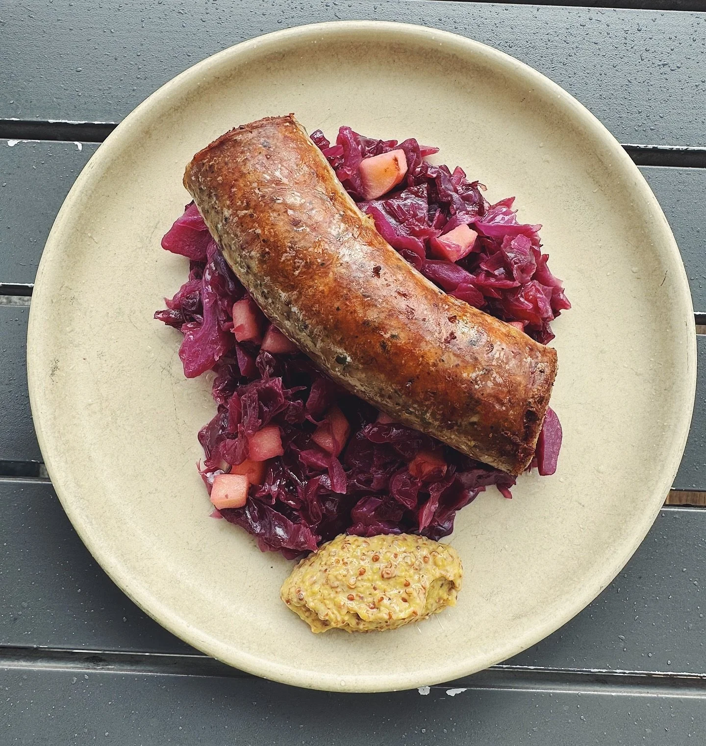 We&rsquo;re leaning into autumn with today&rsquo;s special: Housemade pork sausage, stewed red cabbage and apple, grainy mustard. It started to drizzle as we took this photo, and made it feel even more fitting to enjoy comfort food like this 💜