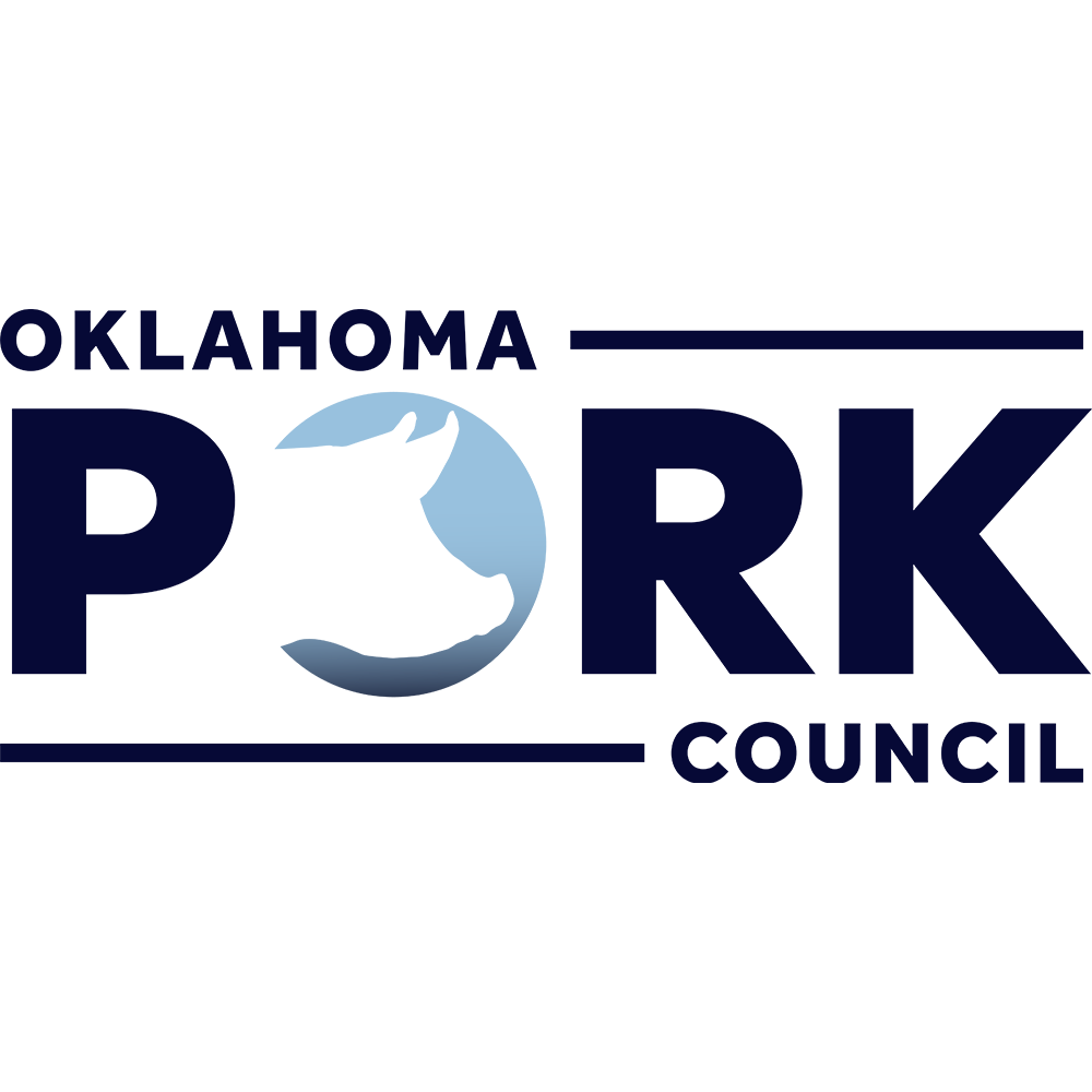 Close-up of a person holding a smartphone in front of a laptop with a coffee cup nearby, on a dark blue desk.