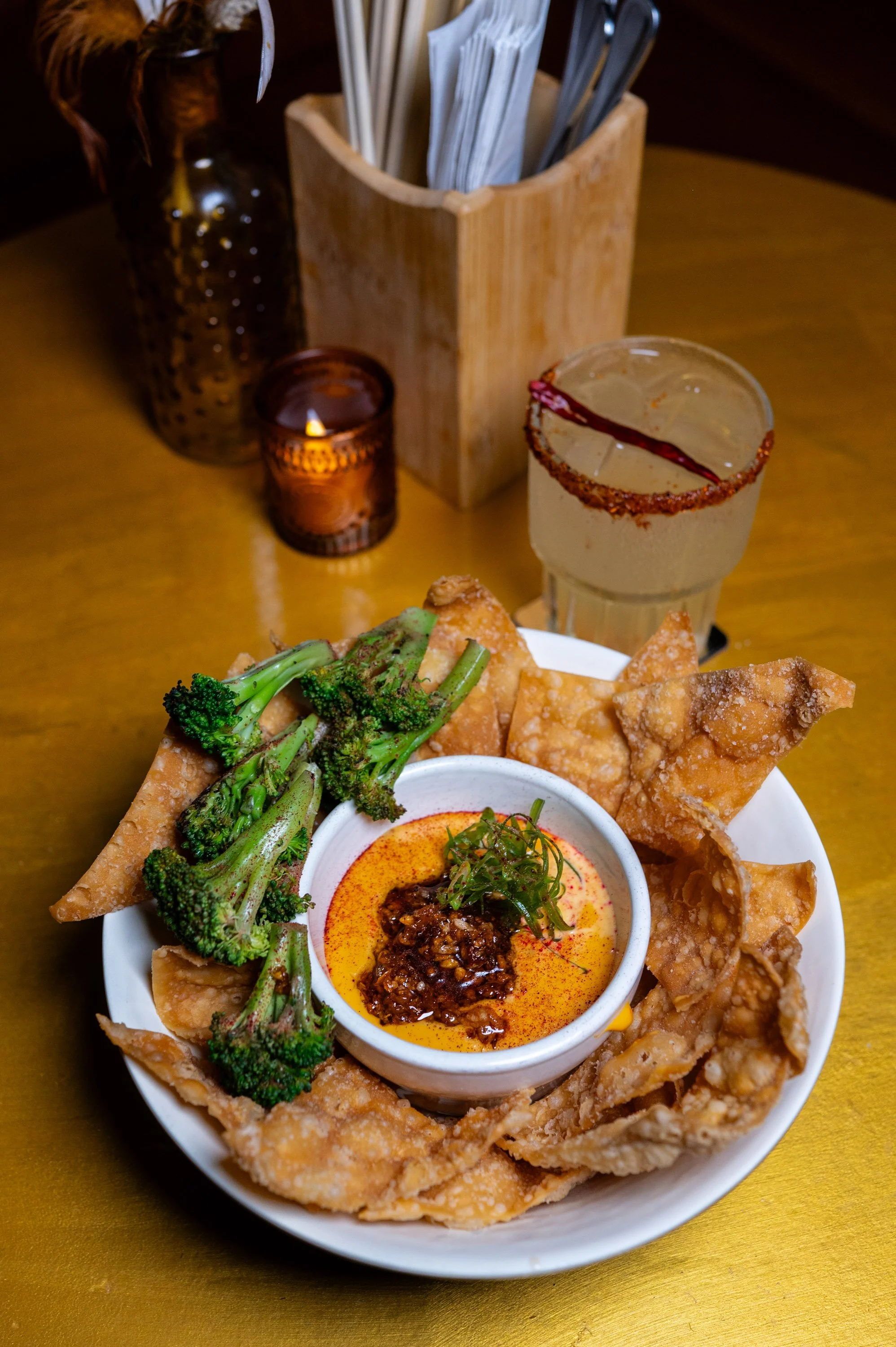 Our award-winning Black Garlic Queso. House chili crisp, wonton chips, wok charred broccoli.