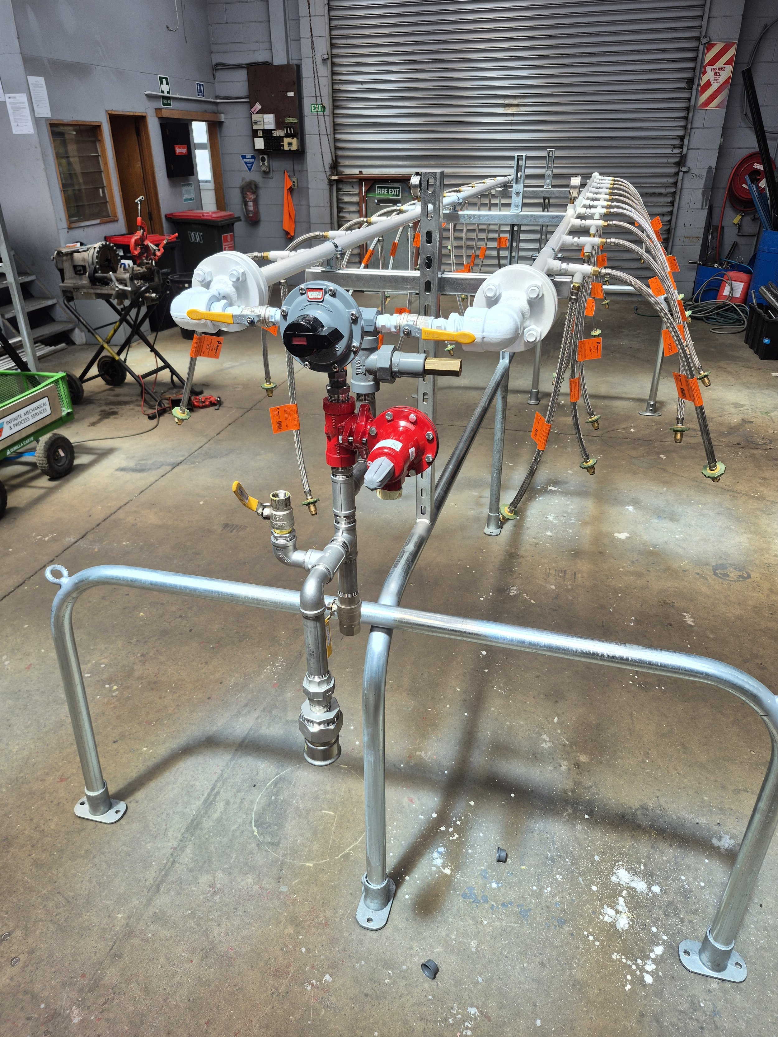 Industrial piping system with valves and gauges in a warehouse setting.