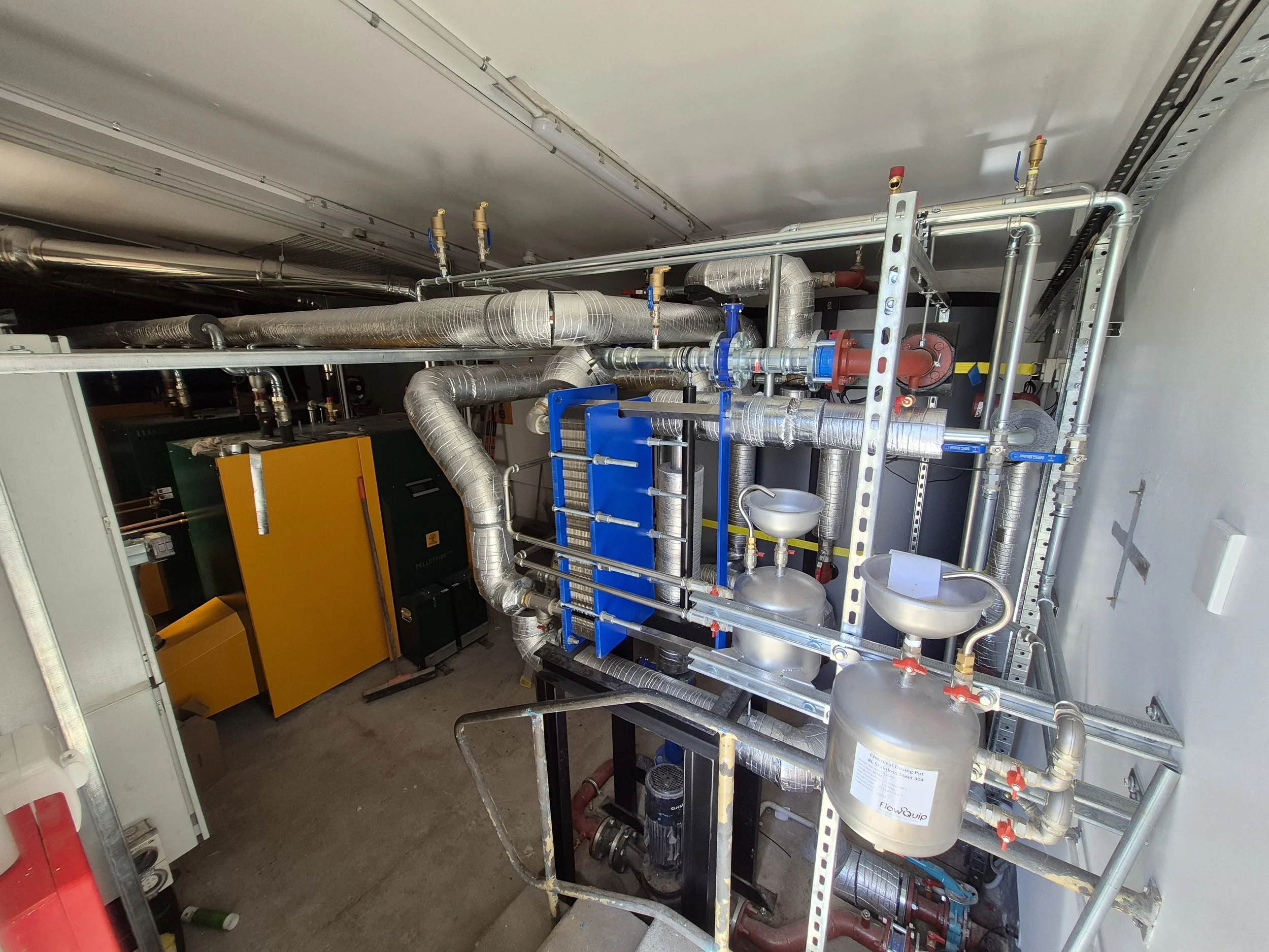 Mechanical room with various pipes, valves, and HVAC equipment.