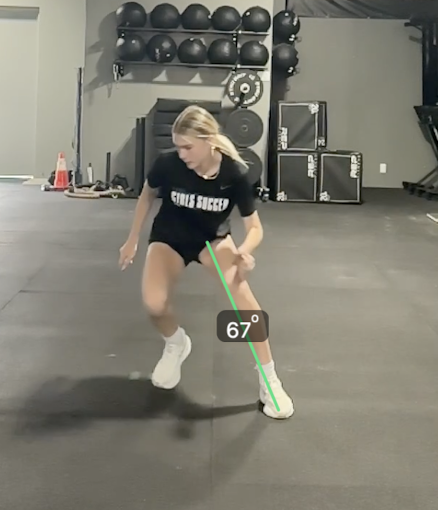 A woman in a gym performing a balance exercise with a measuring line indicating 67 degrees.