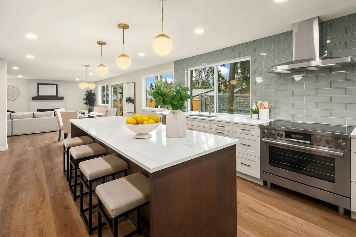 A staged kitchen island and open-concept dining room in Edmonds, WA featuring modern neutral decor and professional styling by Essential Home Staging.